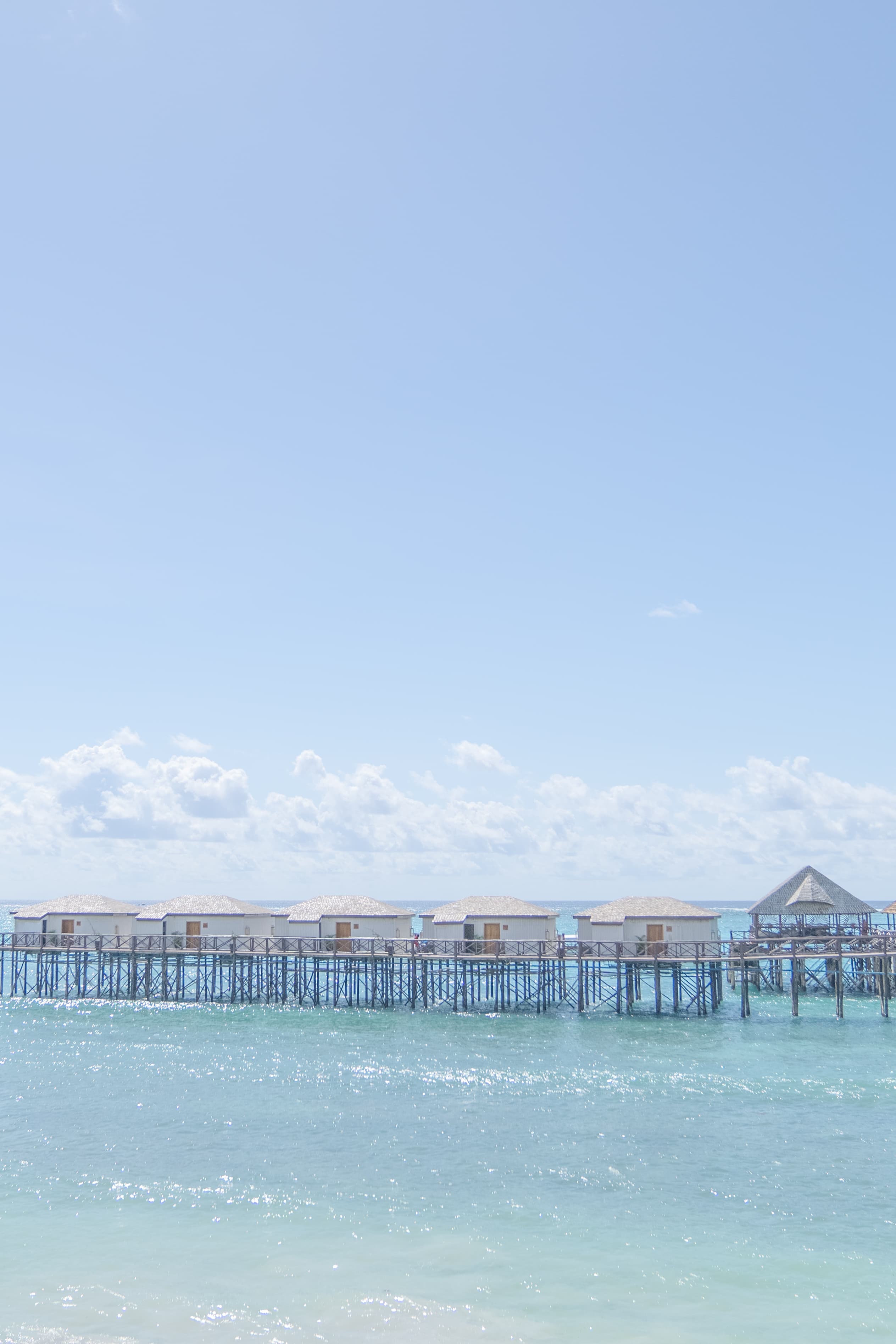 Pier buildings and structure stand proudly in the waves on a sunny day.