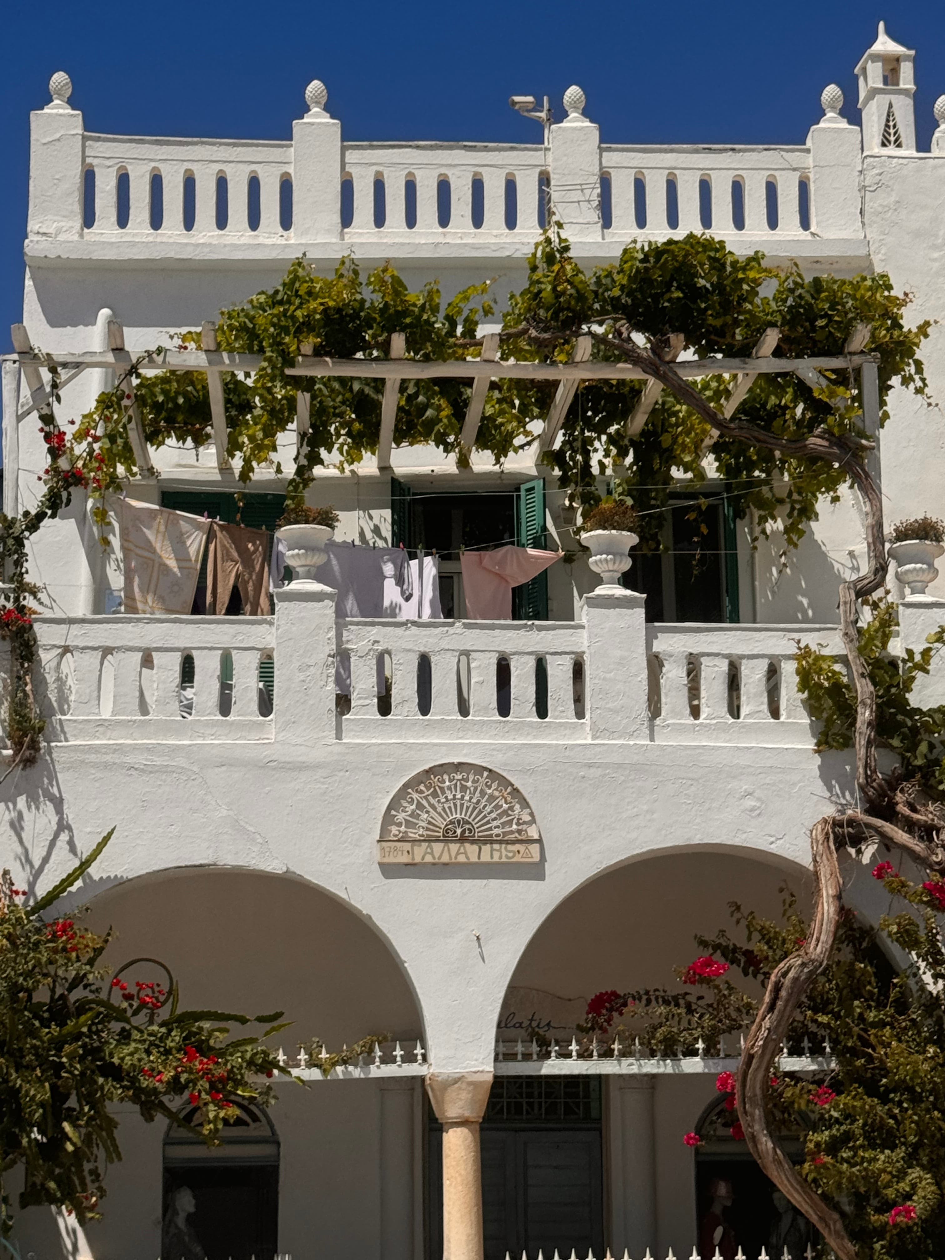 A beautiful white hotel with foliage during the daytime. 