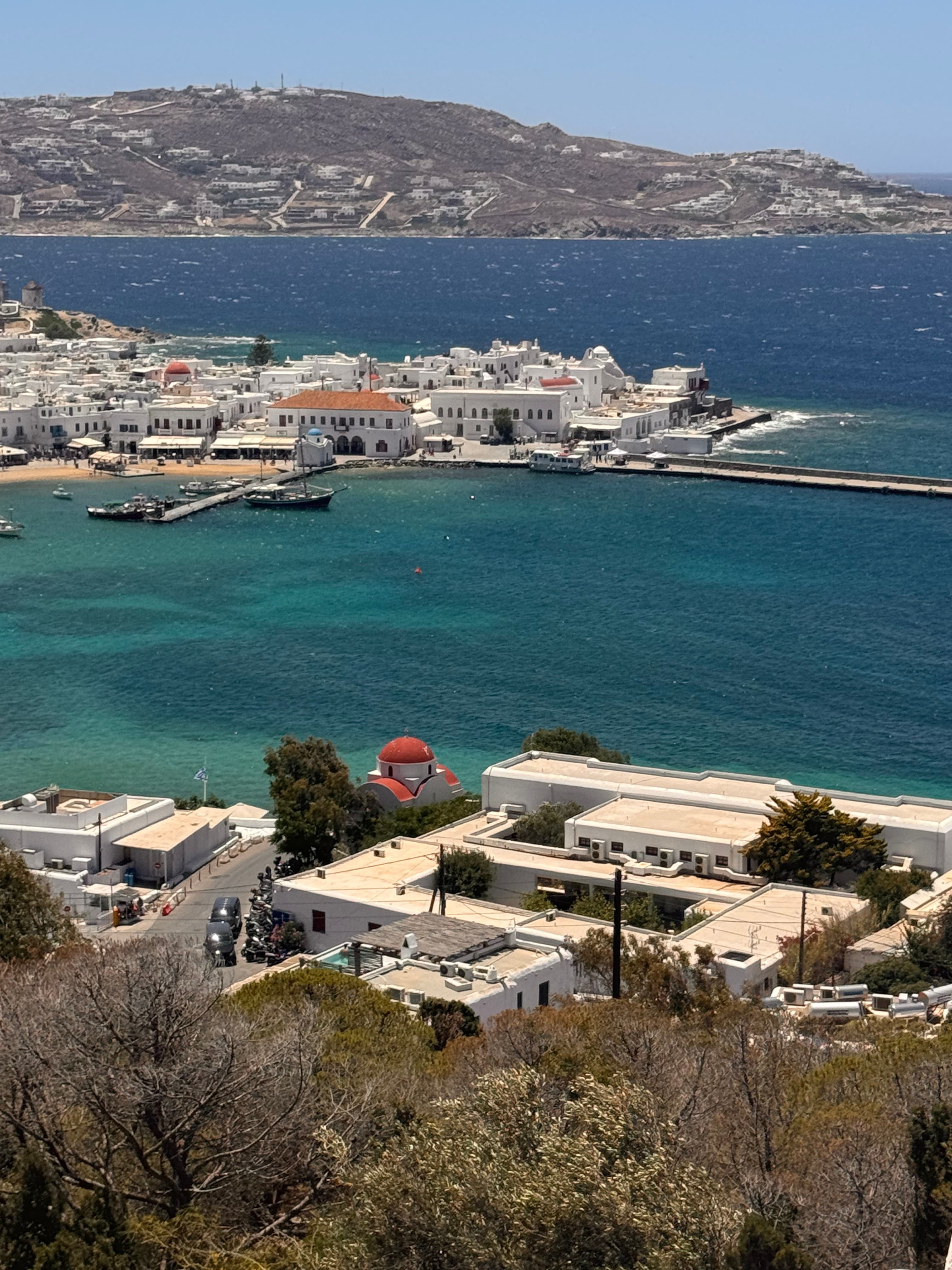 A view of the ocean with a seaside town in the distance on a sunny day. 