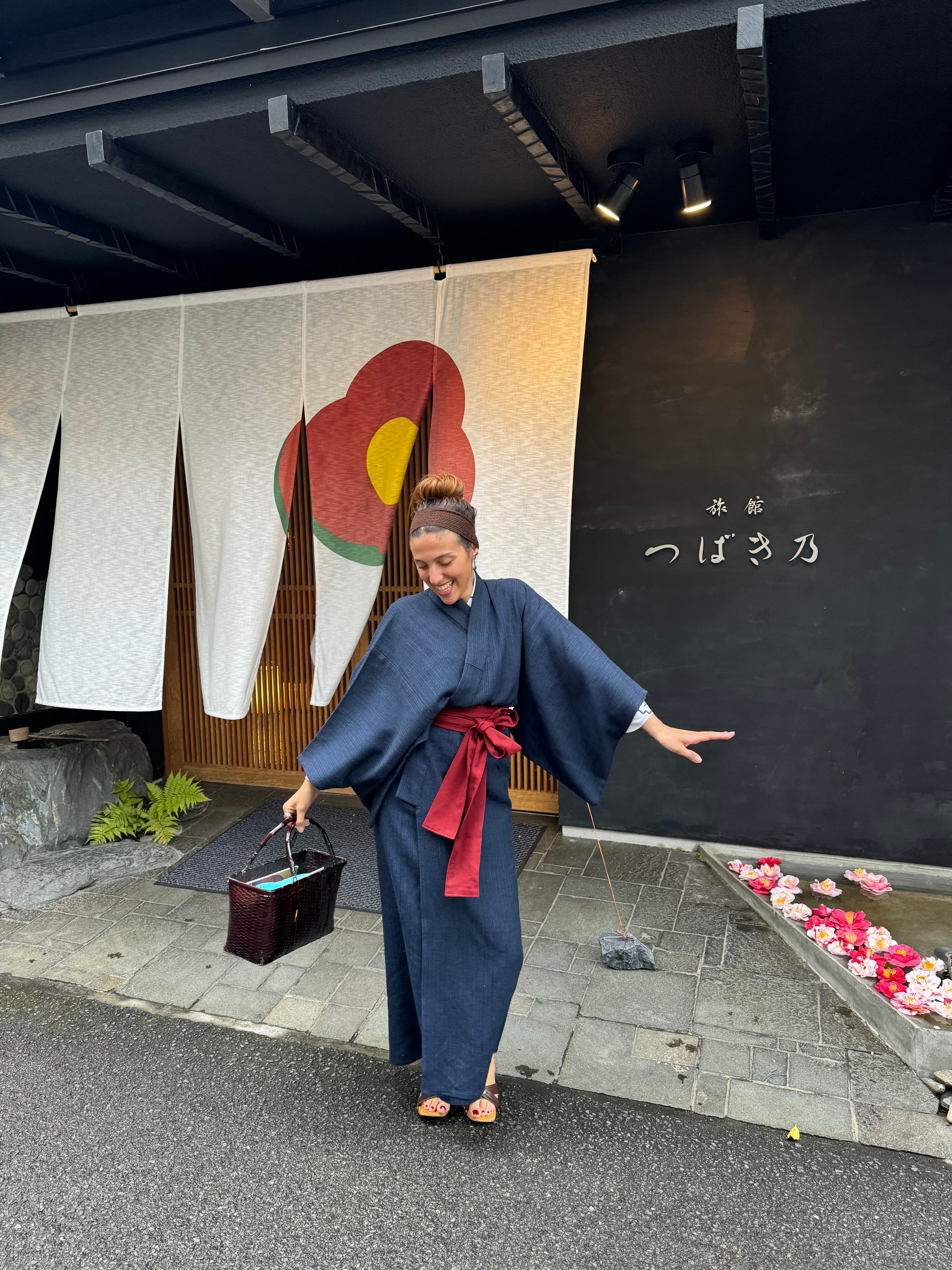 Advisor posing in a blue kimono in front of a building.