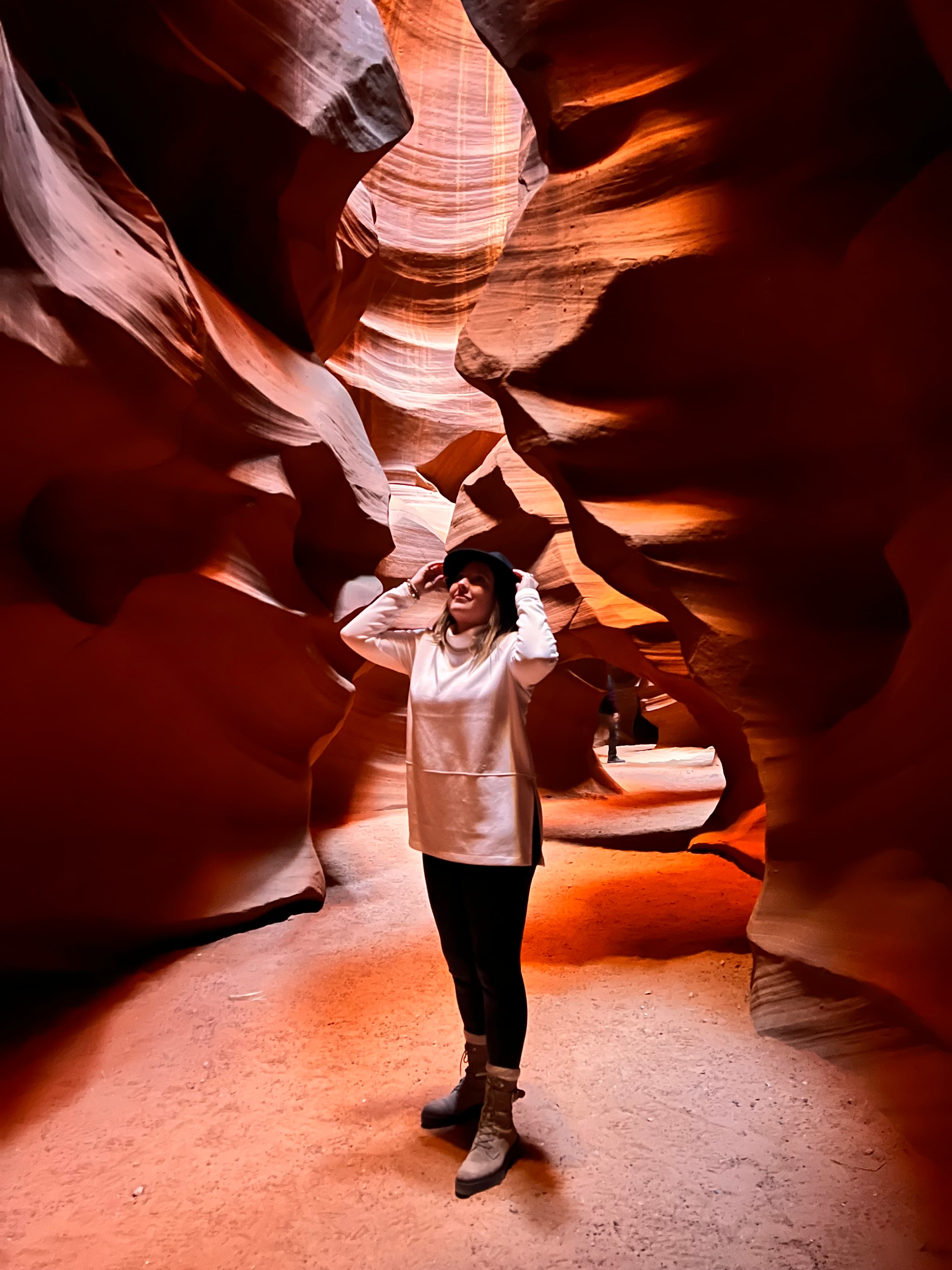 Advisor standing in the crevice of a beautiful red rock formation with sunlight streaming in