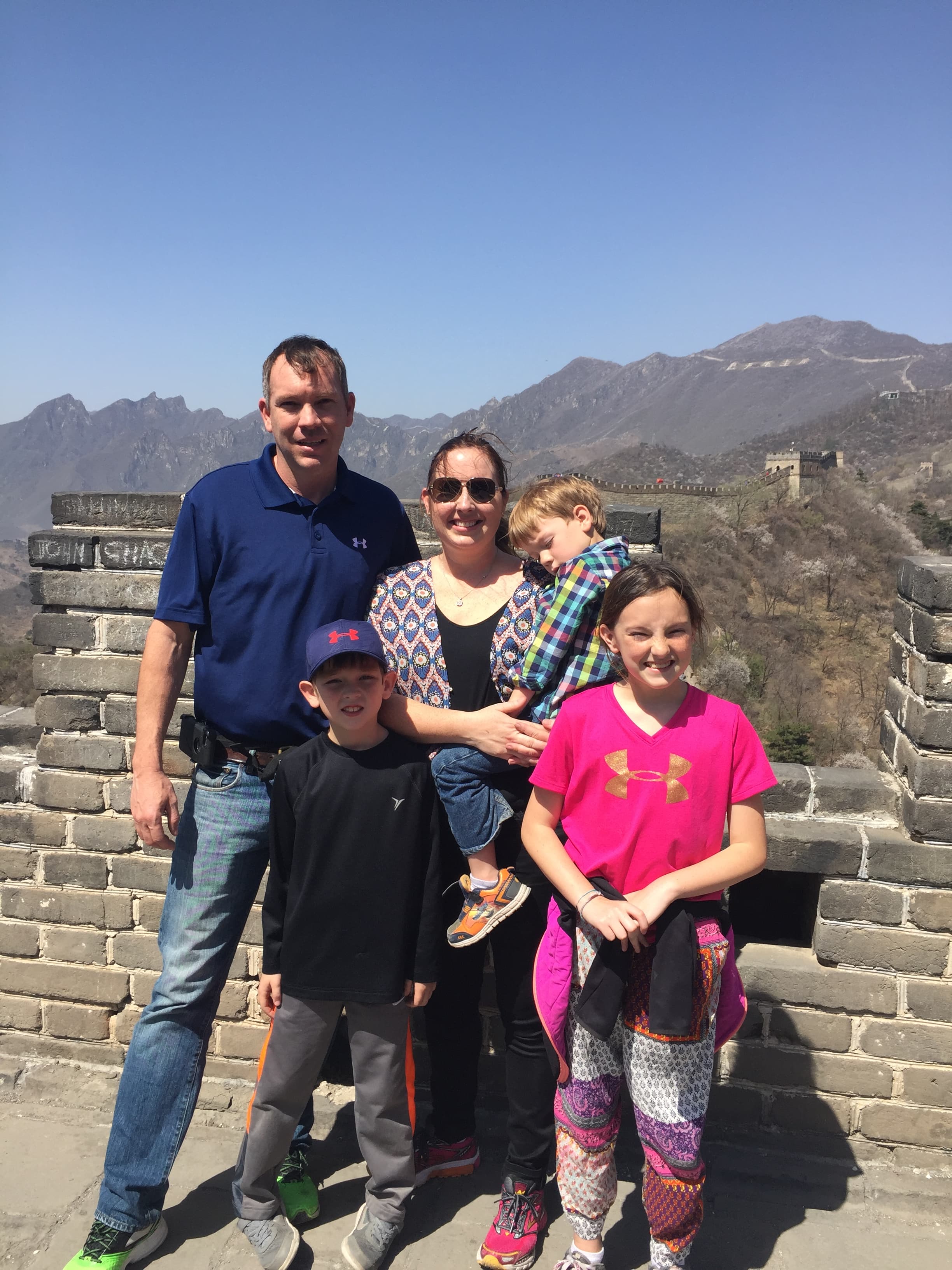 Advisor and her family posing on the Great Wall of China under clear skies