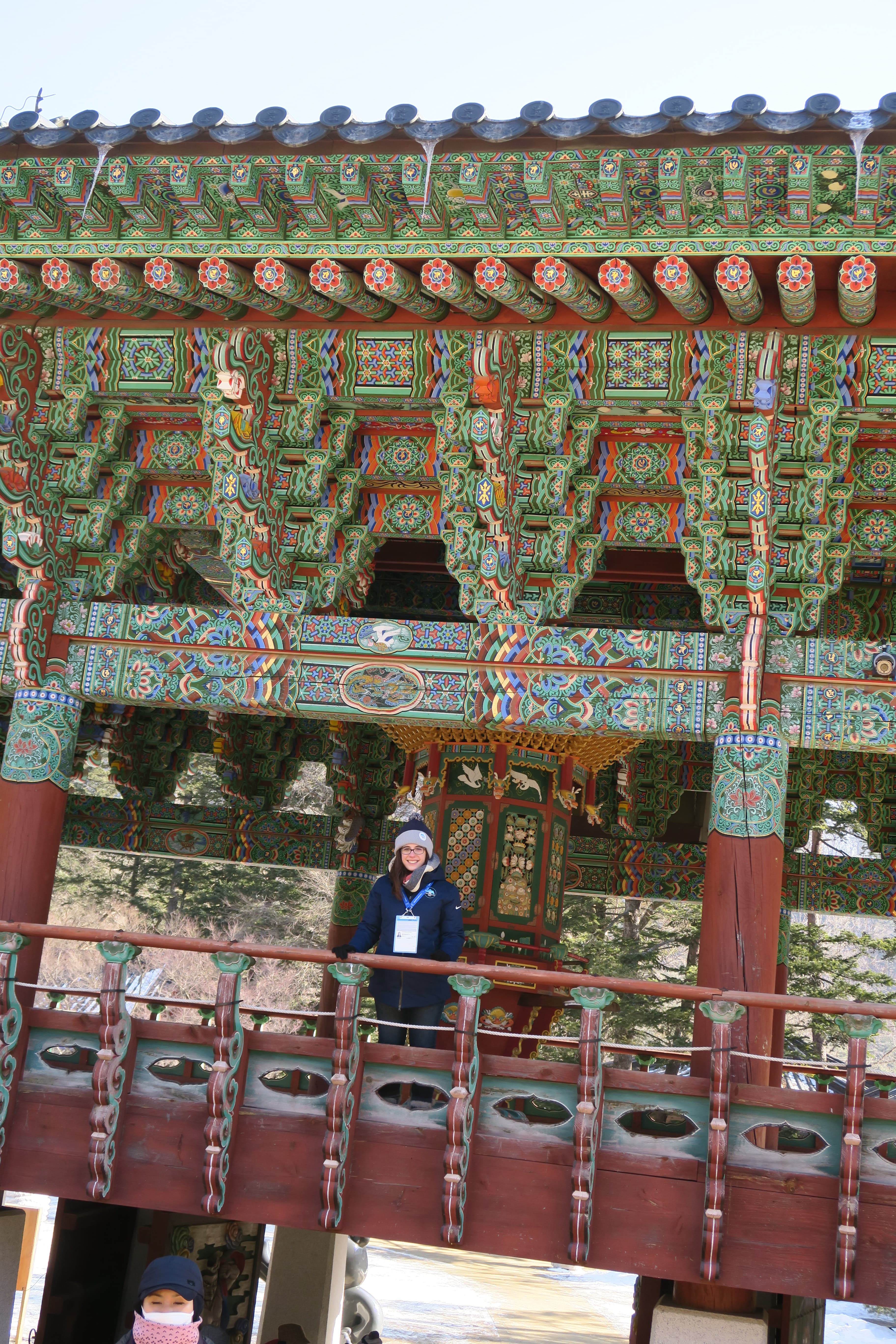 View of an ornate red/green temple and advisor standing on a platform