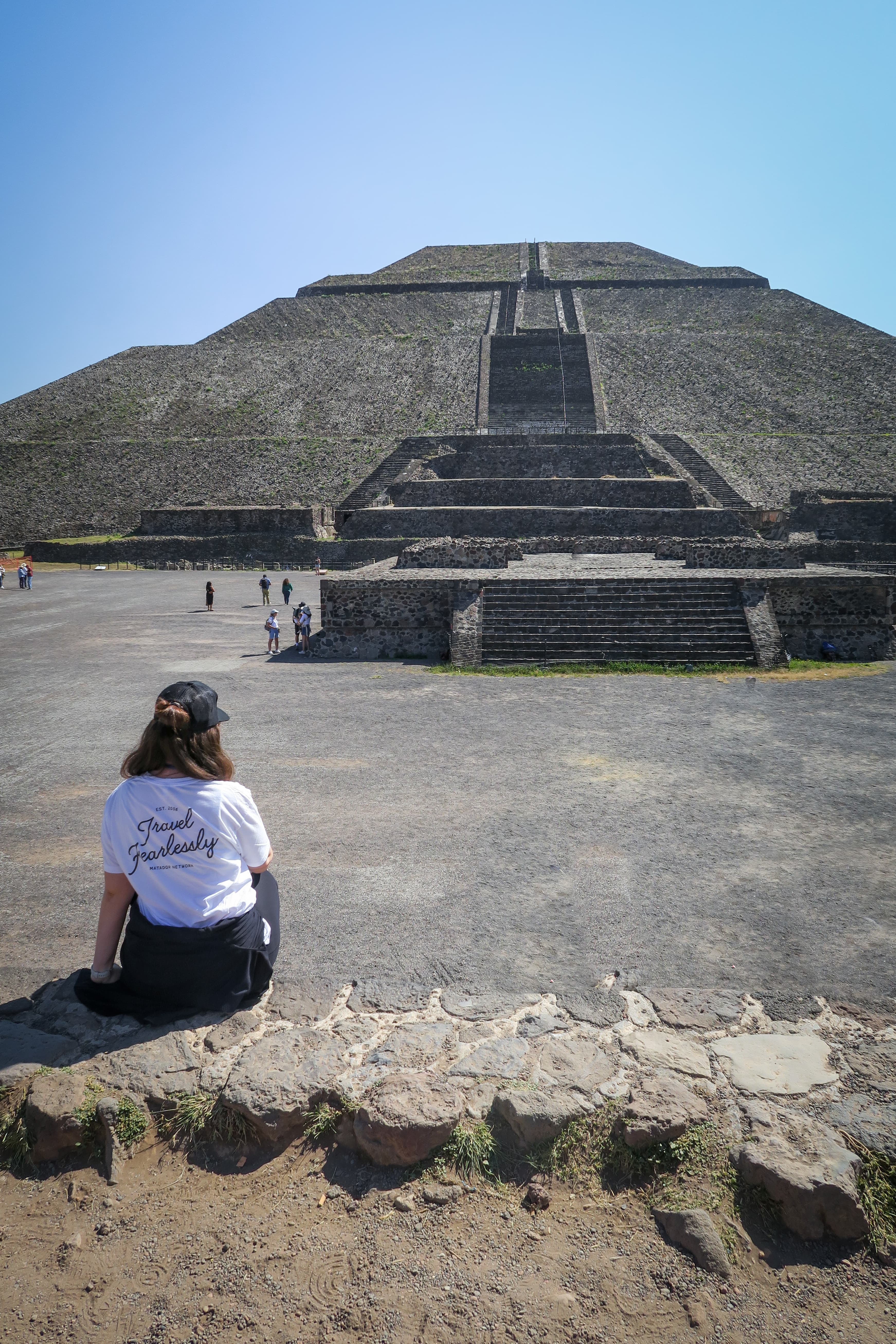 View of advisor sitting at the Temple of the Sun, an enormous ancient pyramids, outside of Mexico City on a sunny day