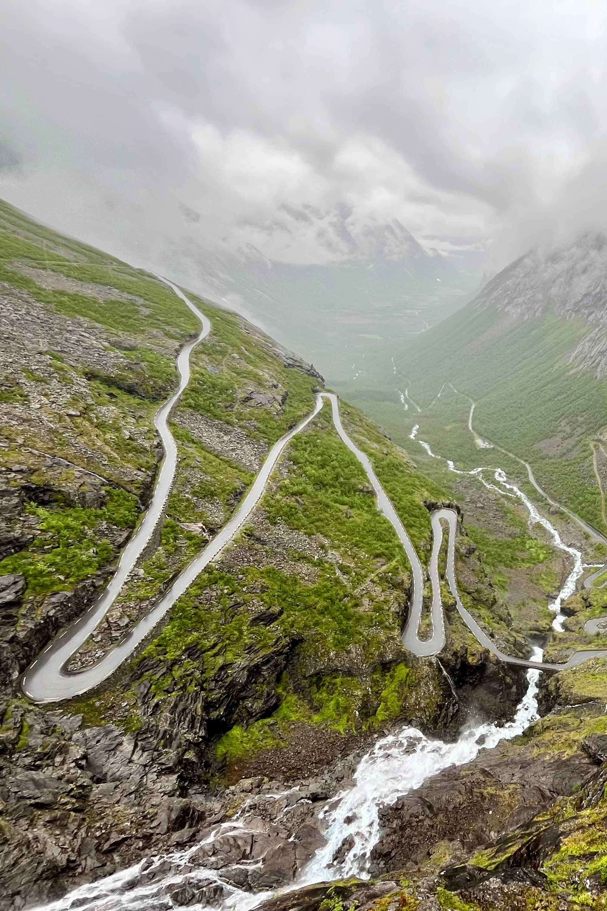 An aerial view of a hiking path with green fields on a sunny day.