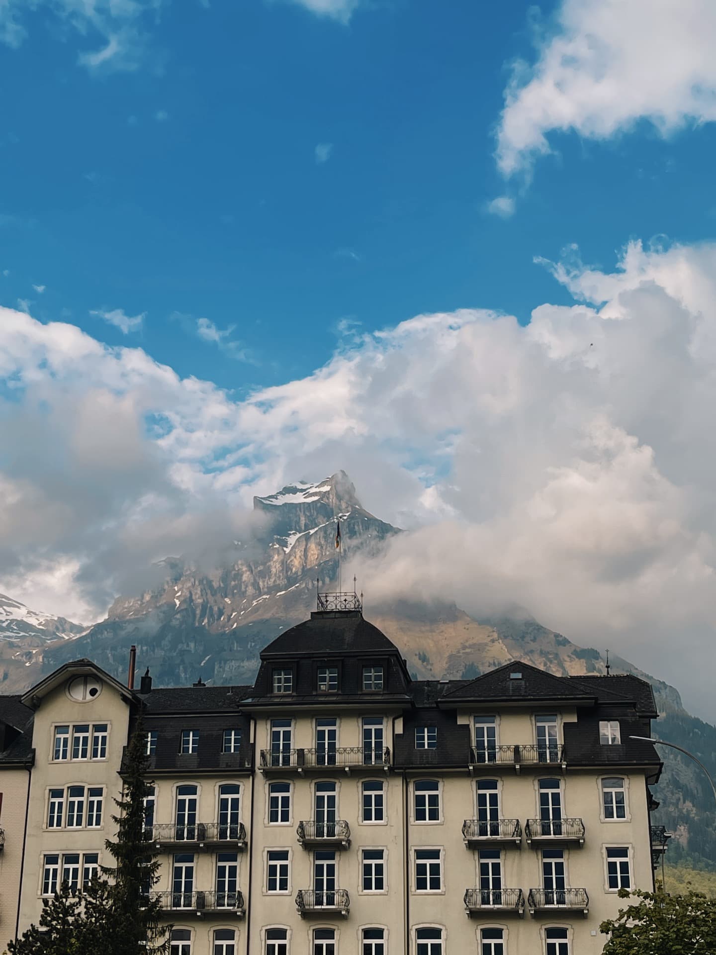 View of a beautiful mountain resort under large fluffy clouds