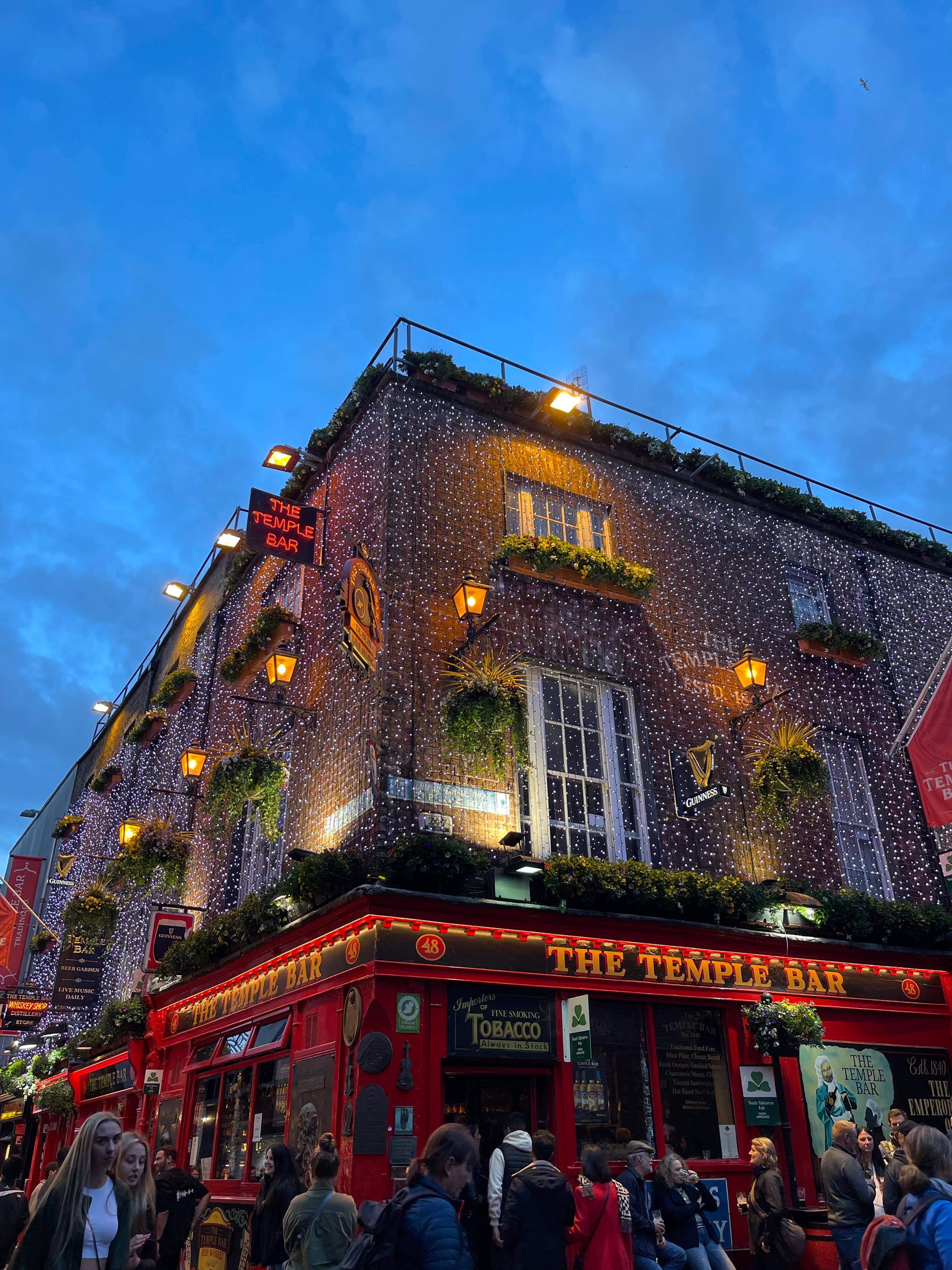 View of Dublin’s Temple Bar with a crowd of tourists in front at dusk