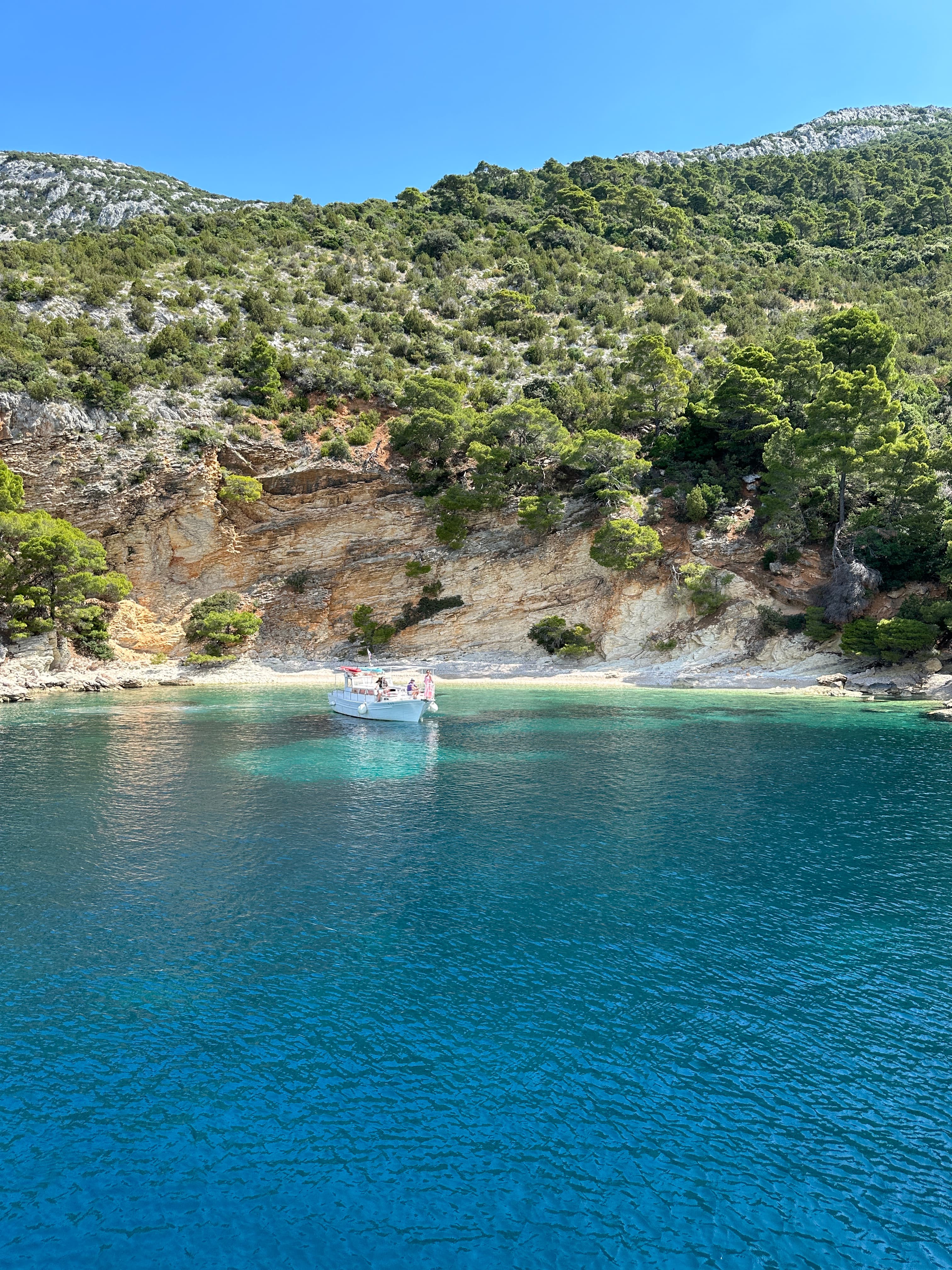 View of beautiful blue ocean water and a small white sand beach seen from the sea