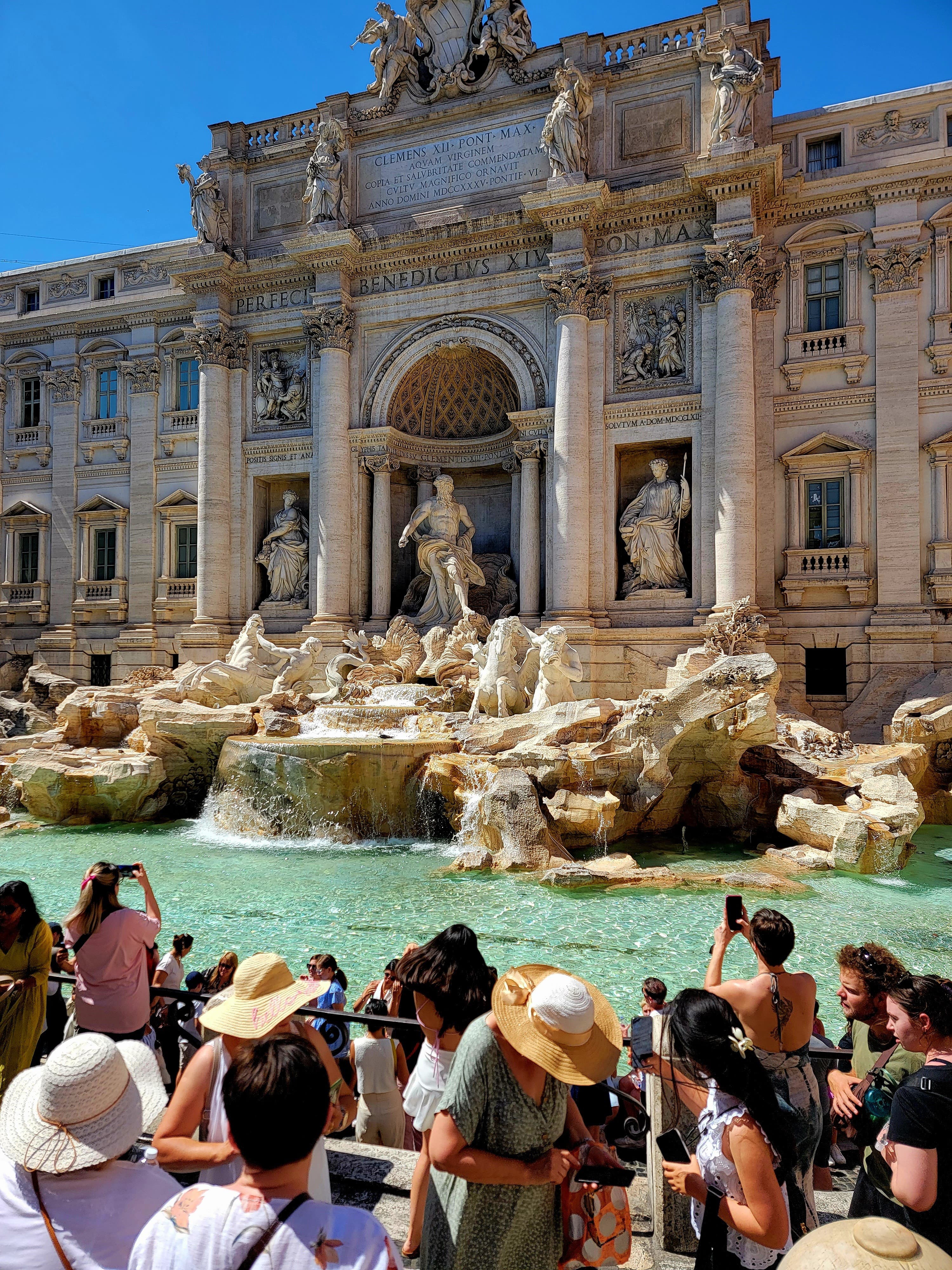 A view of a popular fountain in Italy during the daytime. 