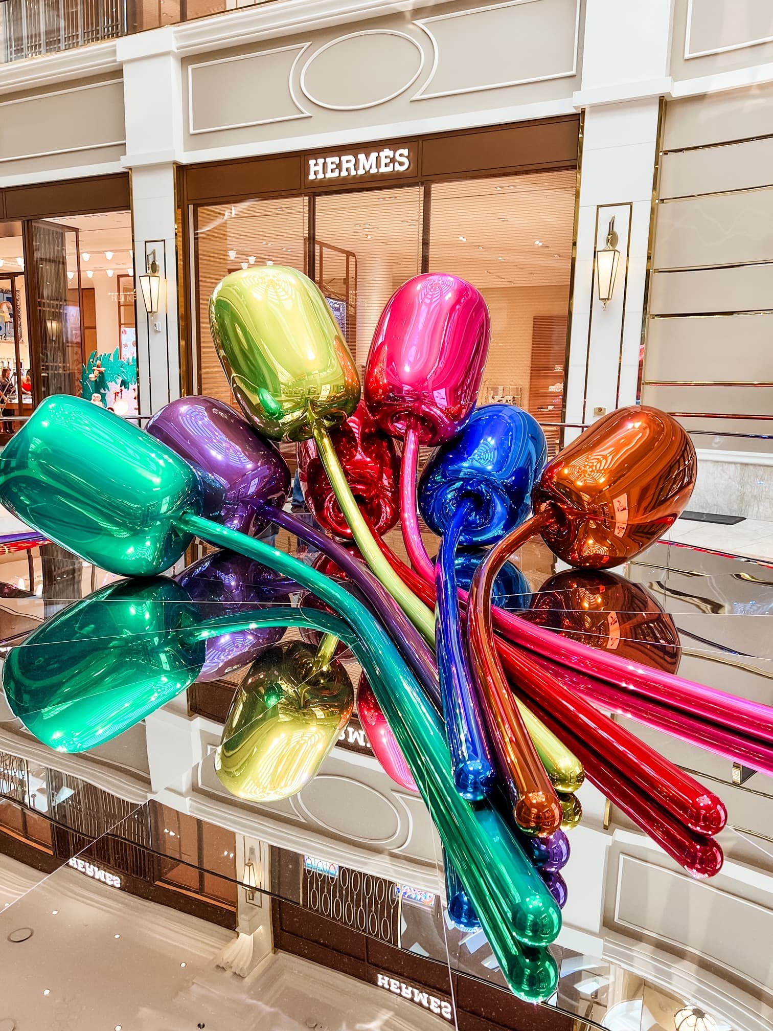 View of multi-colored sculpture in front of a Hermes store in a city