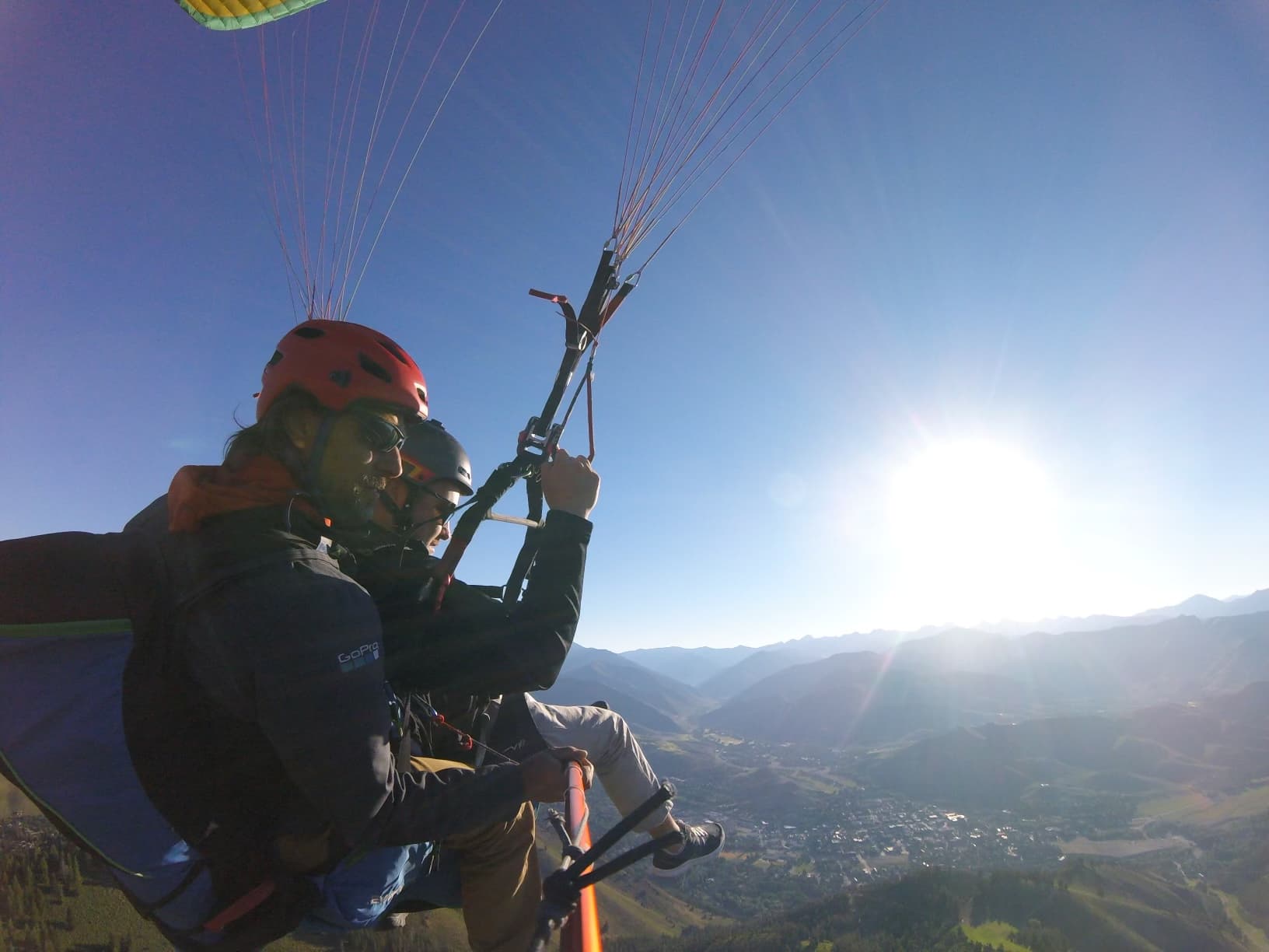 Advisor parasailing high above a mountainous landscape during the day
