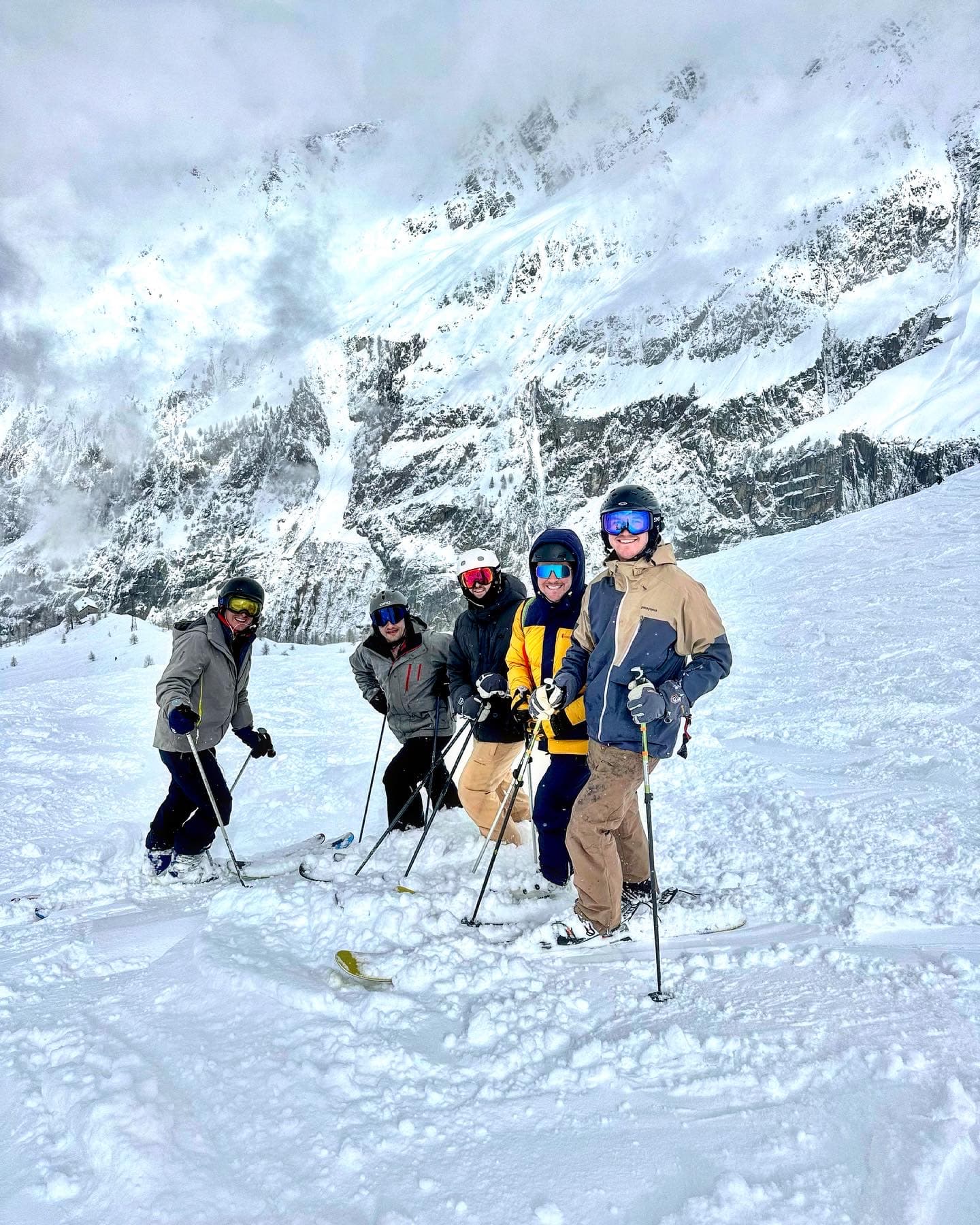 Advisor and friends skiing down the side of a snowy mountain