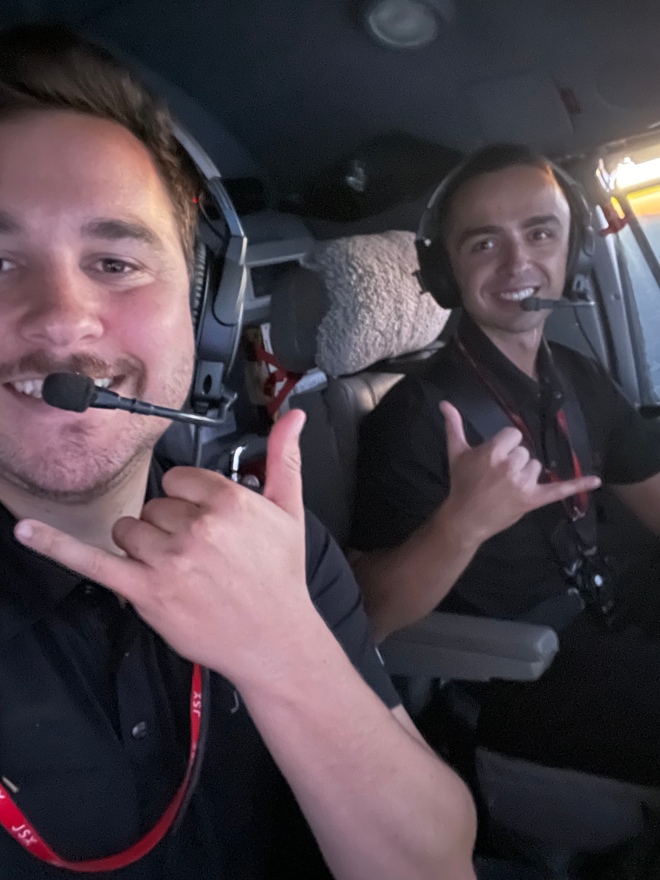 Advisor and a friend wearing headsets in the front seats of a small plane
