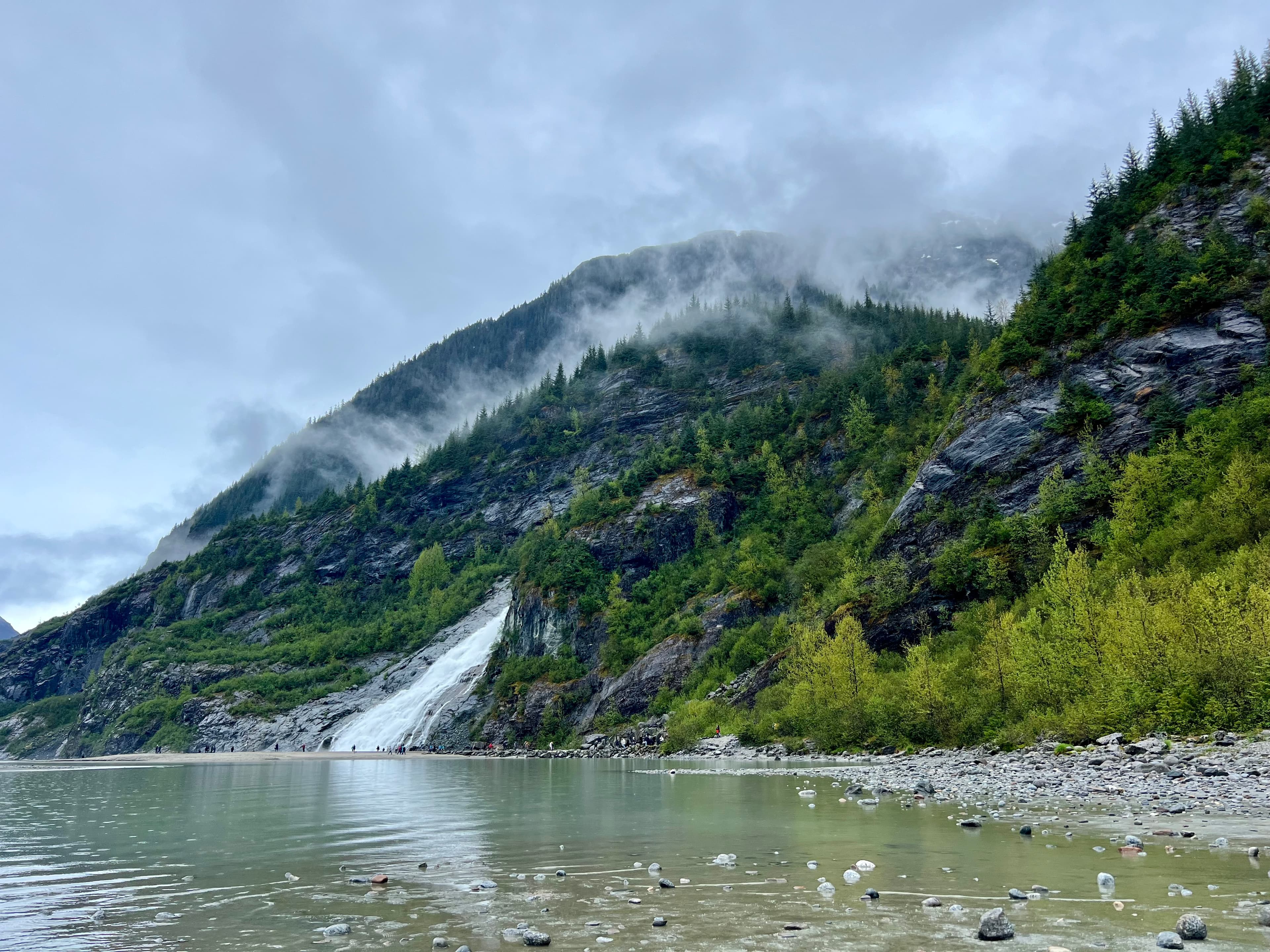 Beautiful view of a lake and lush green mountains under cloudy skies