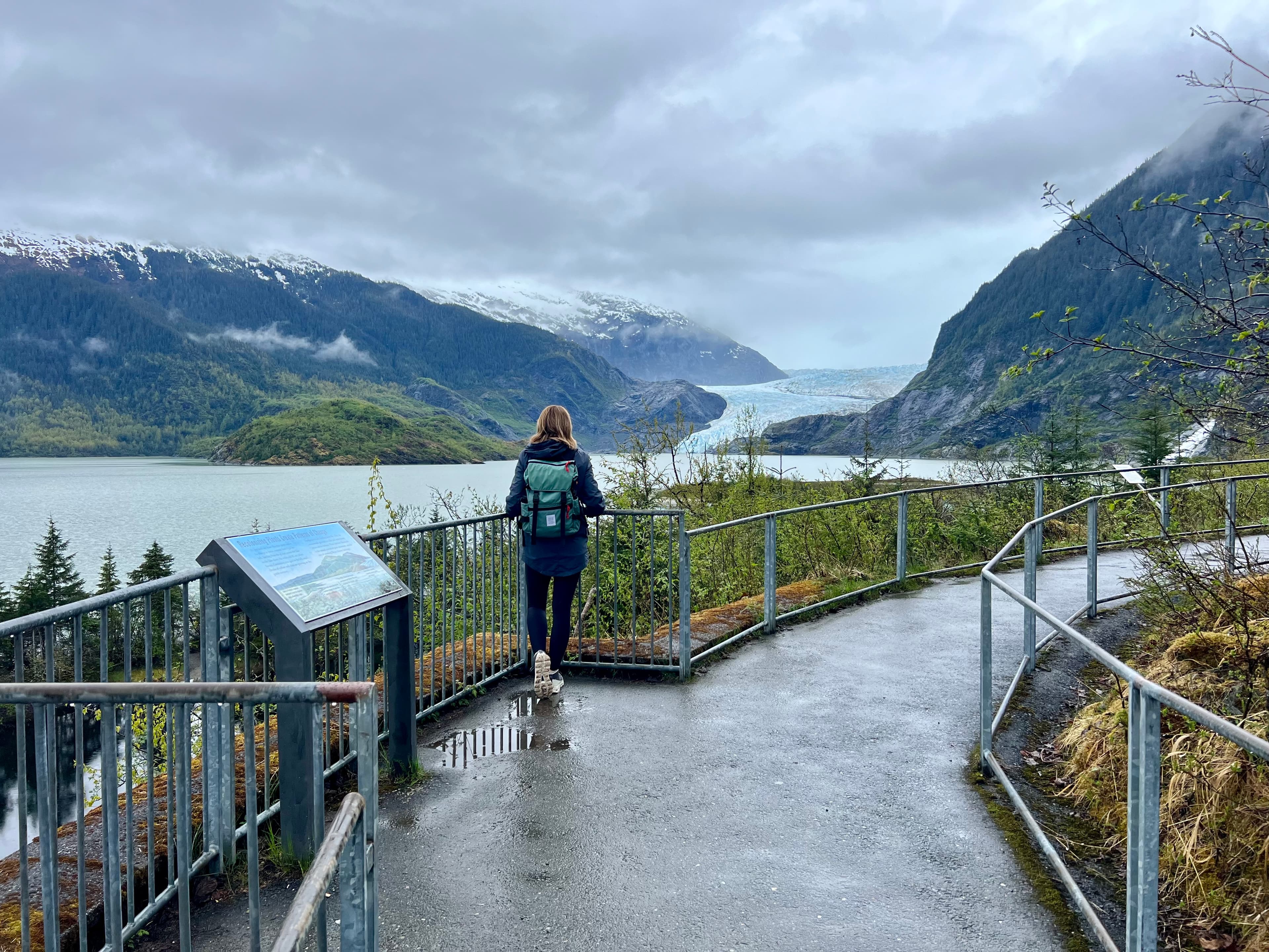 Advisor walking along a path overlooking a scenic lake and mountain view