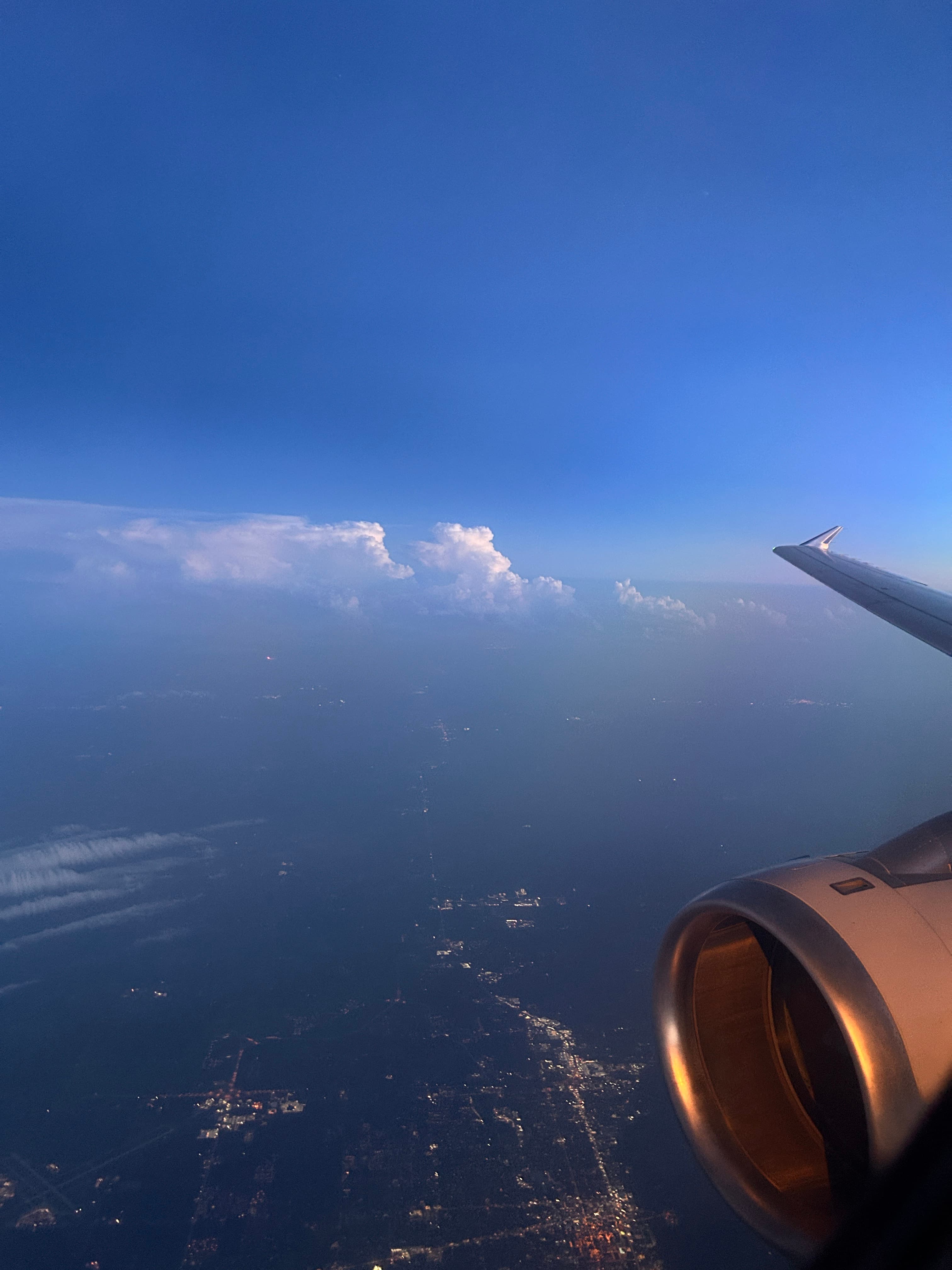 View of the clouds and a plane engine as seen from the window of the plane