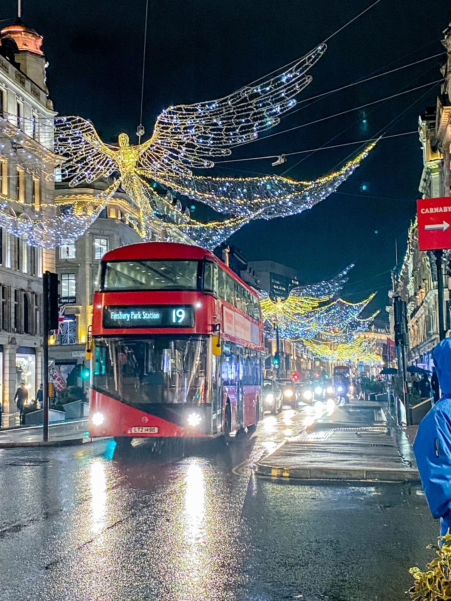 View of a red double decker bus on the street in London at night
