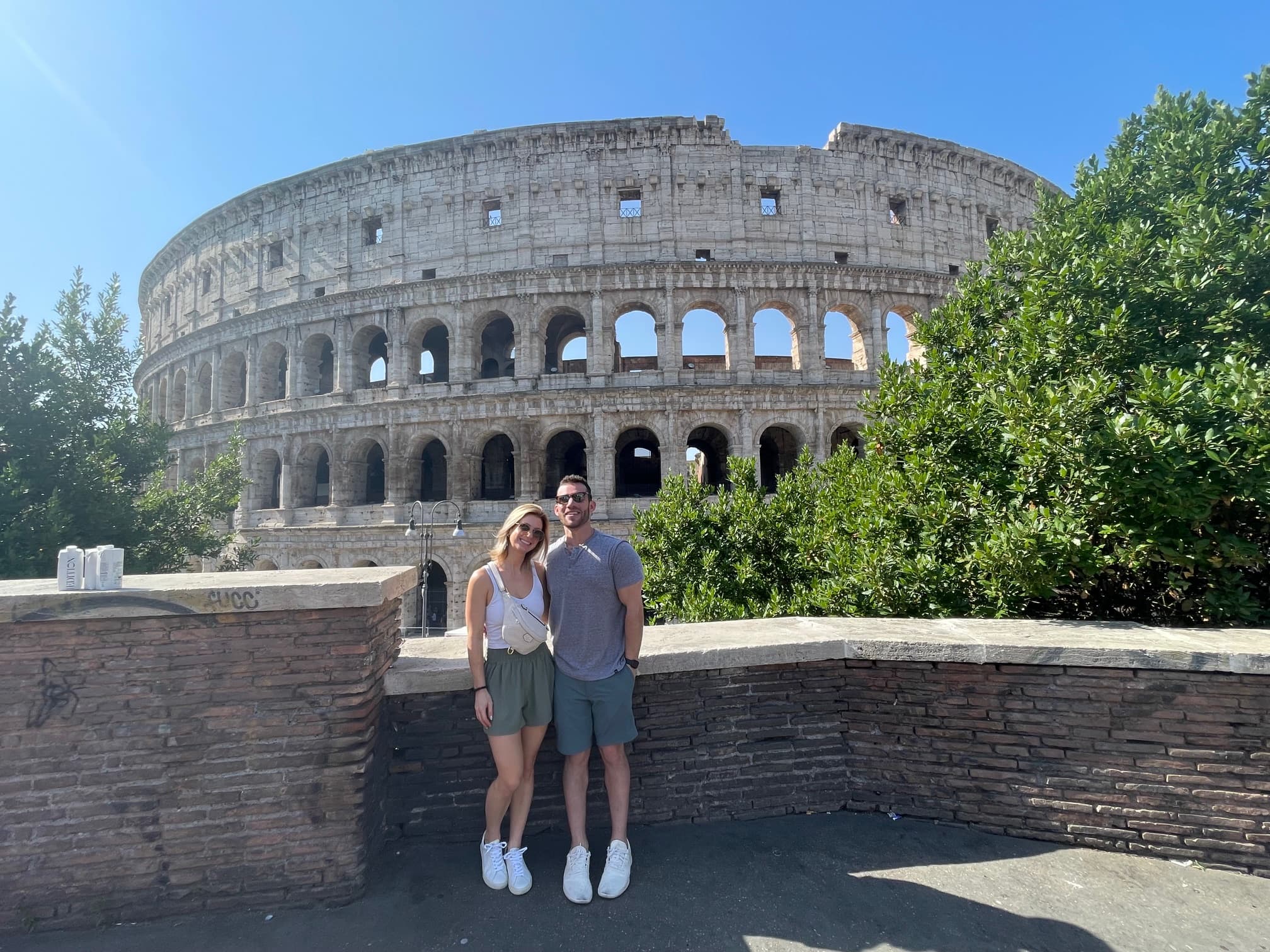 Advisor and her partner smiling side by side on a sunny day with the Colosseum behind them