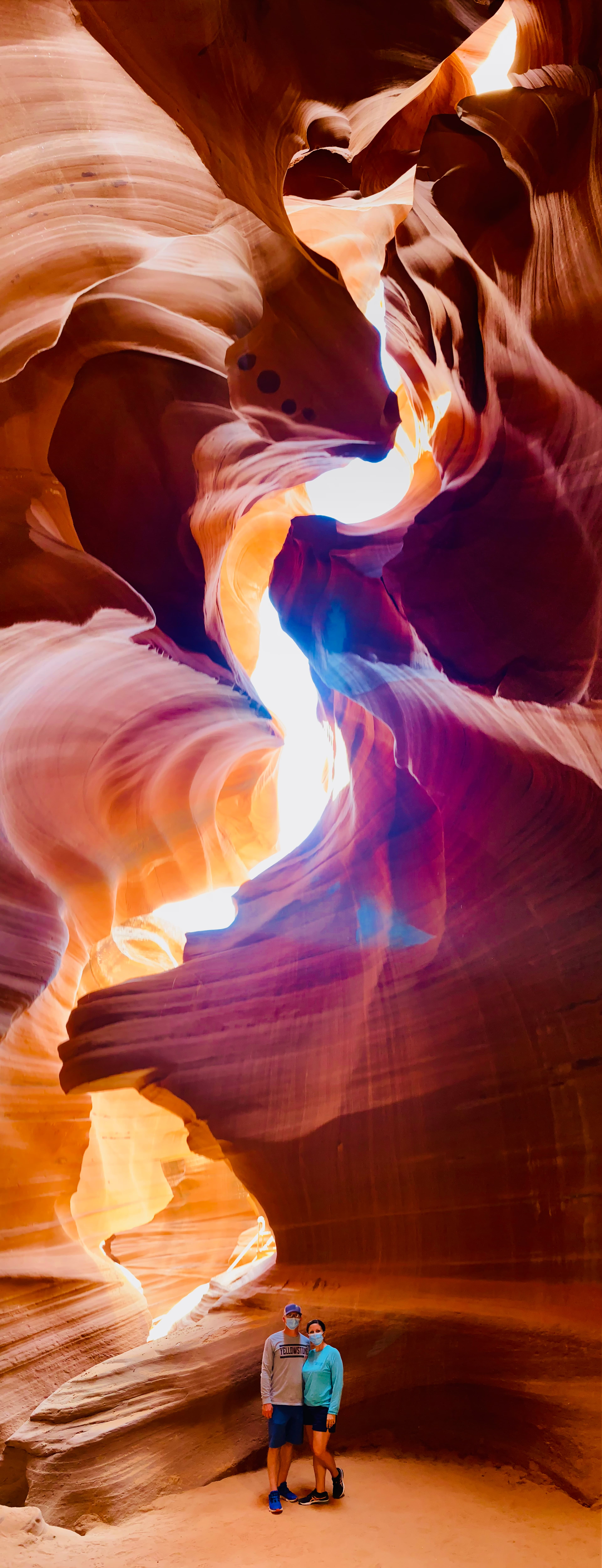 Two people standing inside a slot canyon.