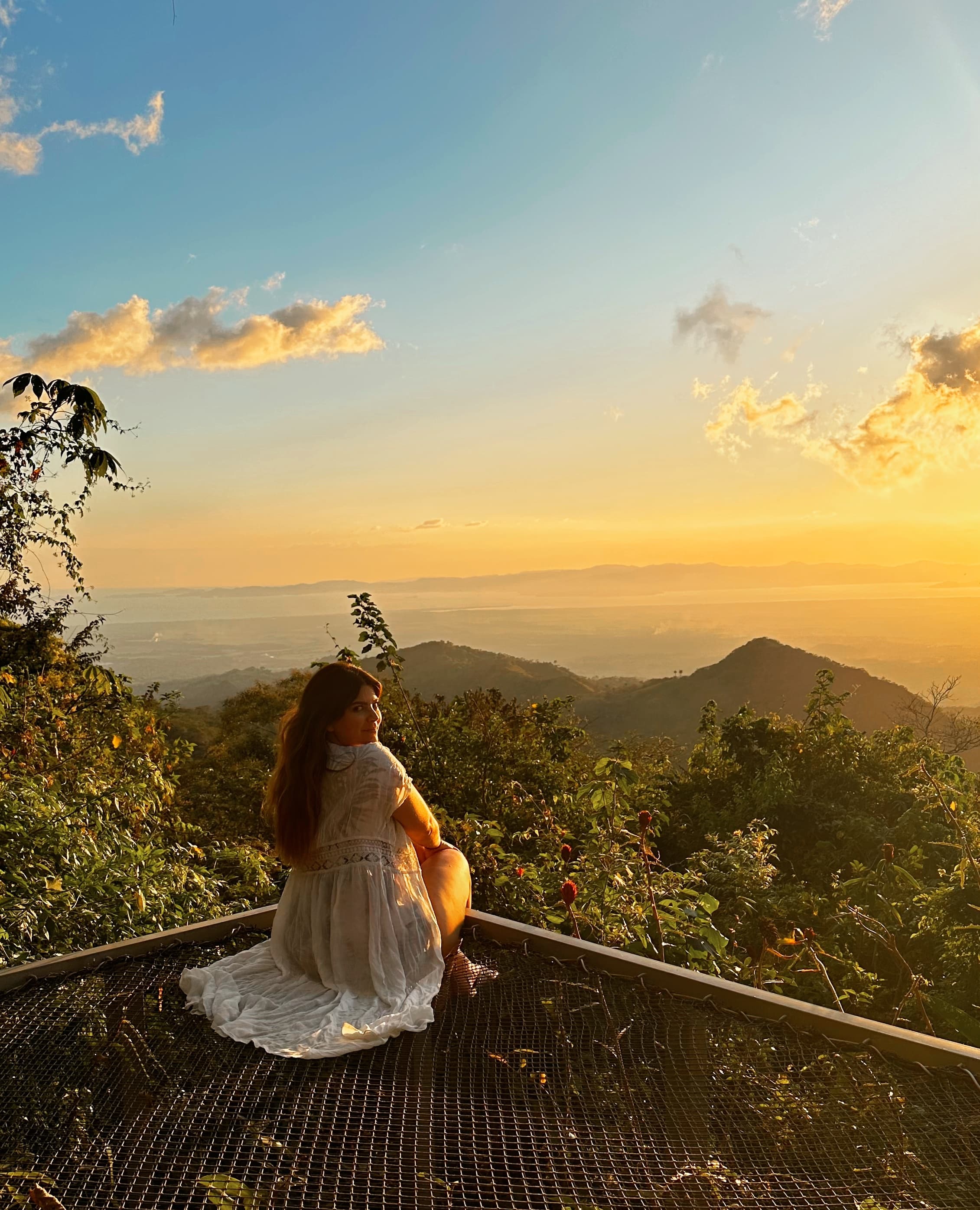 Advisor at a viewpoint overlooking the sea and jungle at sunset