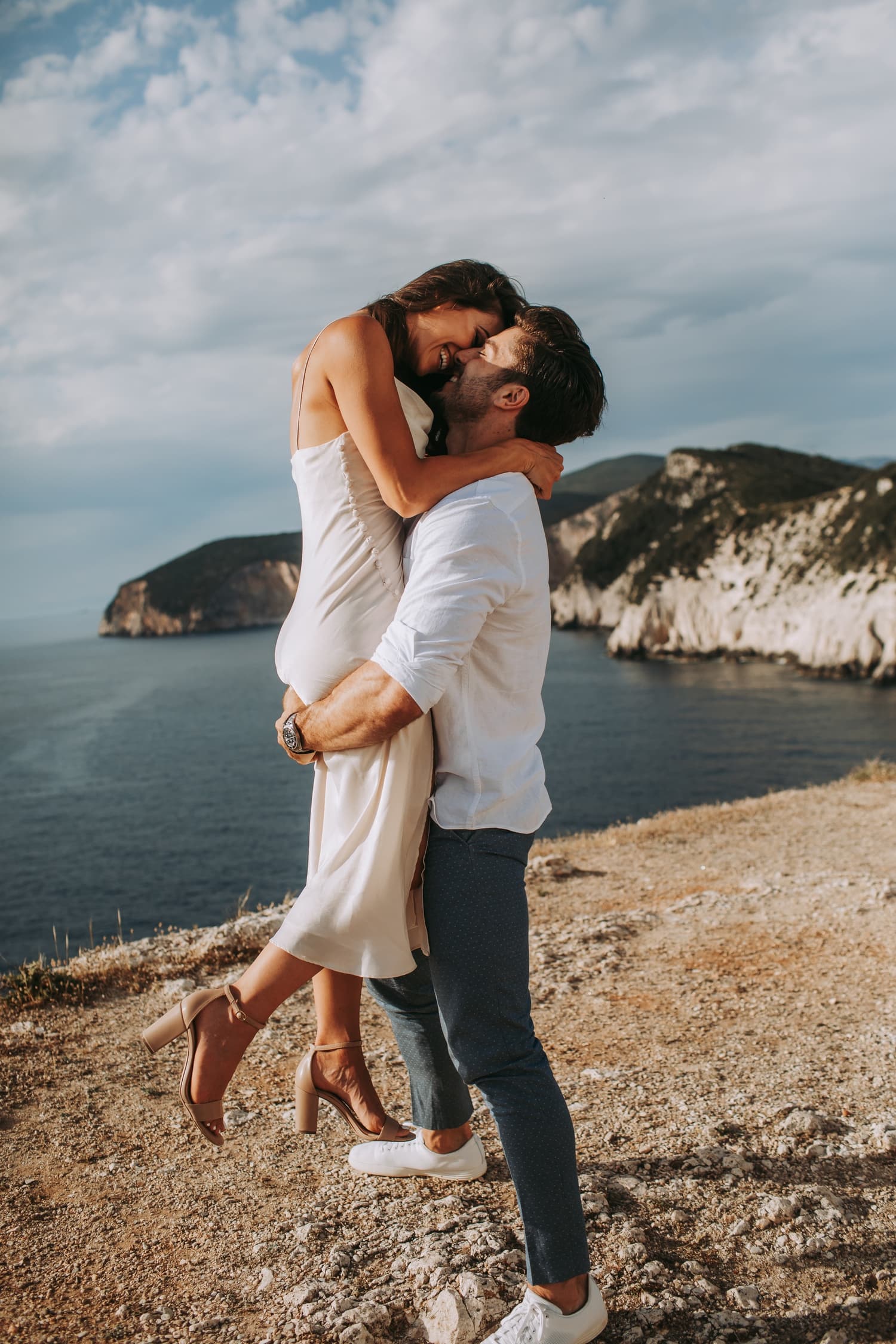 Advisor being lifted up in an embrace by her partner on a sunny beach