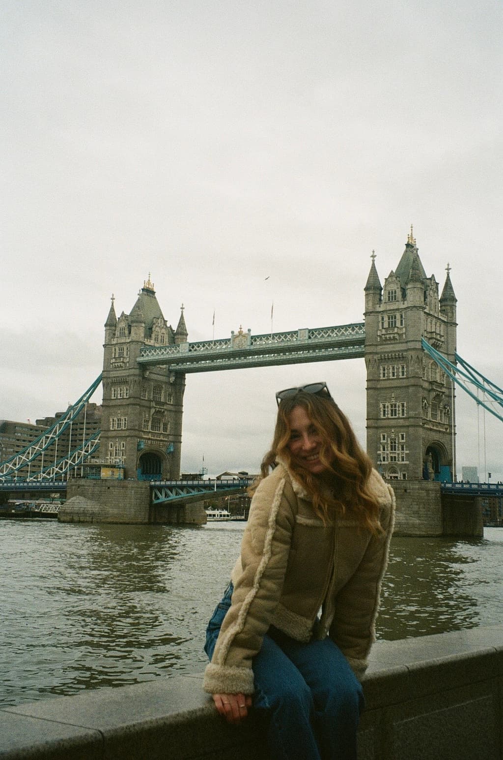 Advisor sitting on a ledge with the London Tower Bridge behind her