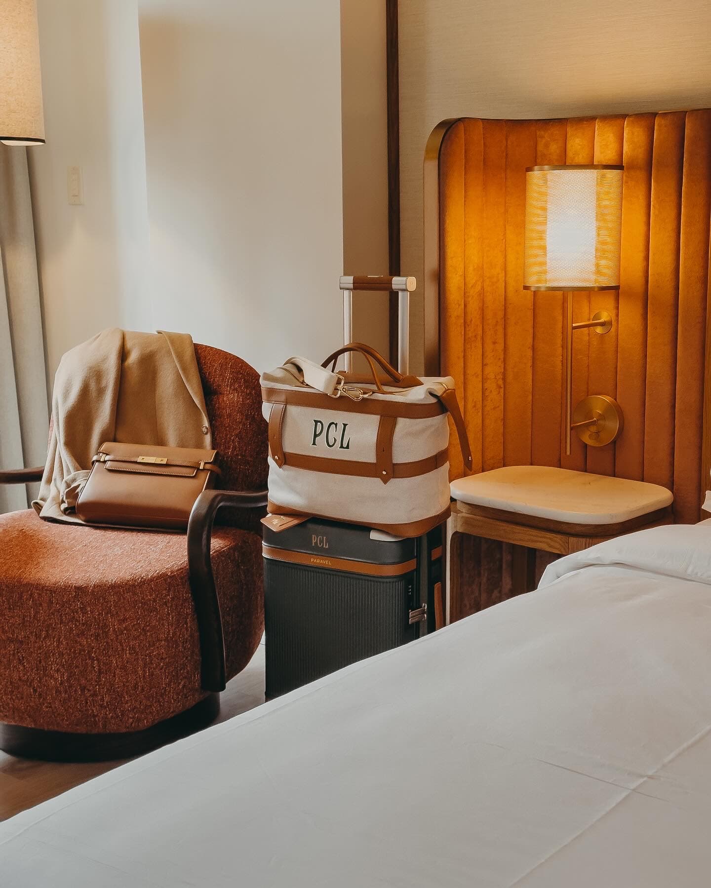 A hotel room with advisor’s luggage, her initials on a tote bag