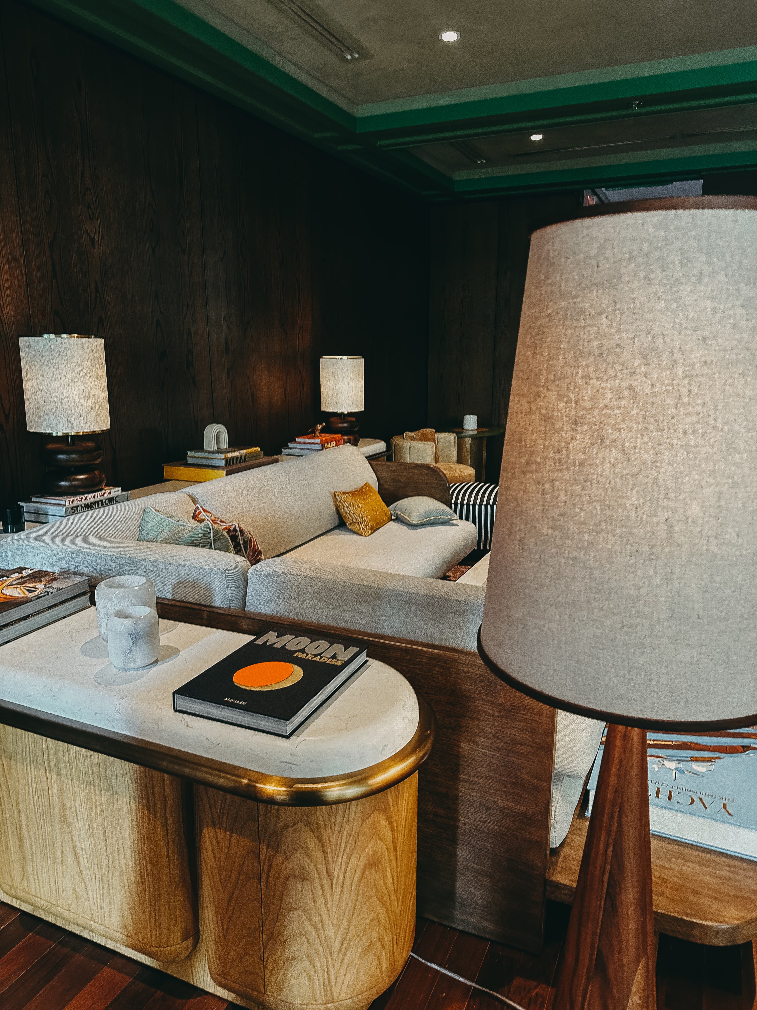 View of a modern hotel lobby with a white couch and dark walls
