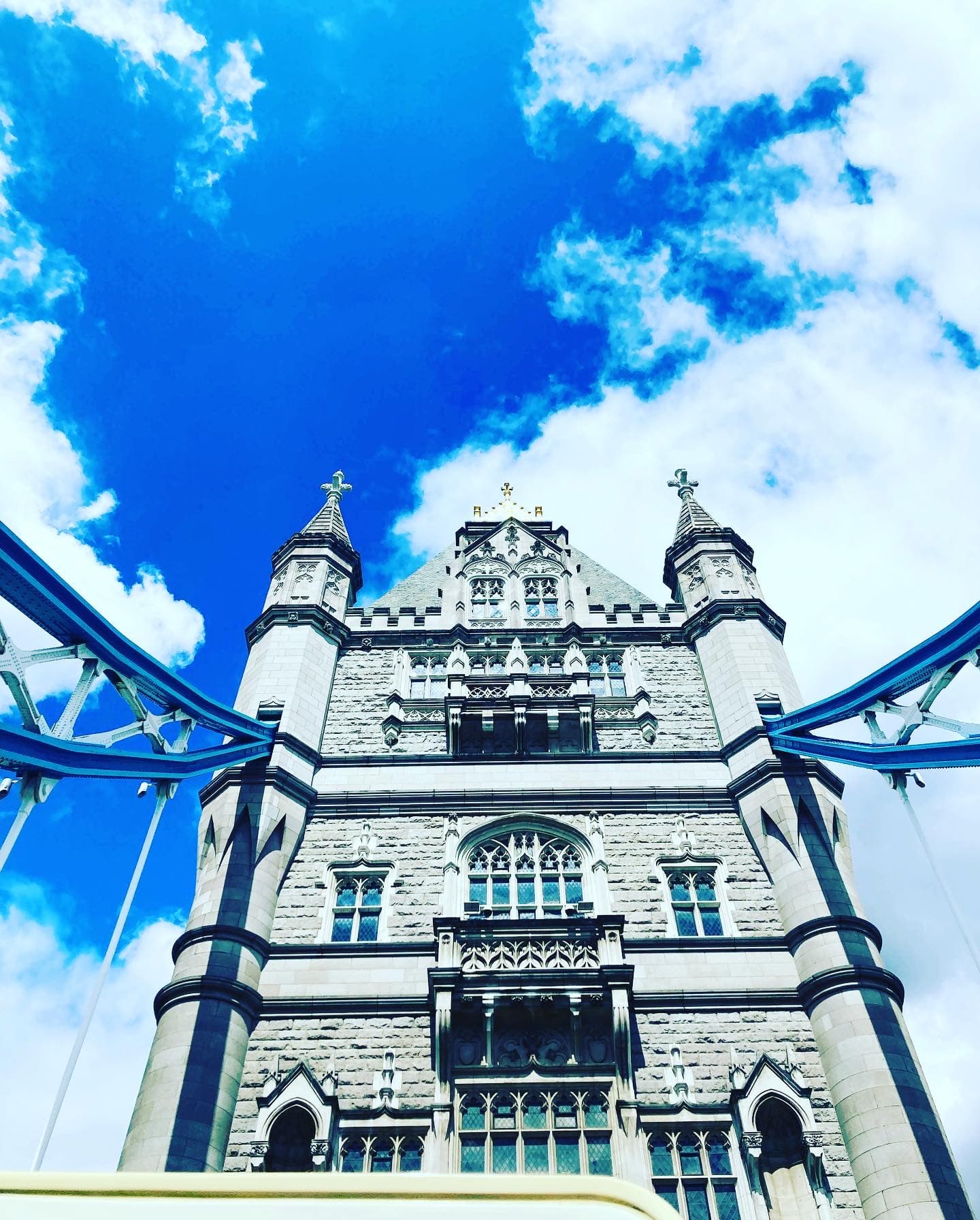 A view of an old historic building in front of a vibrant, cloudy blue sky. 