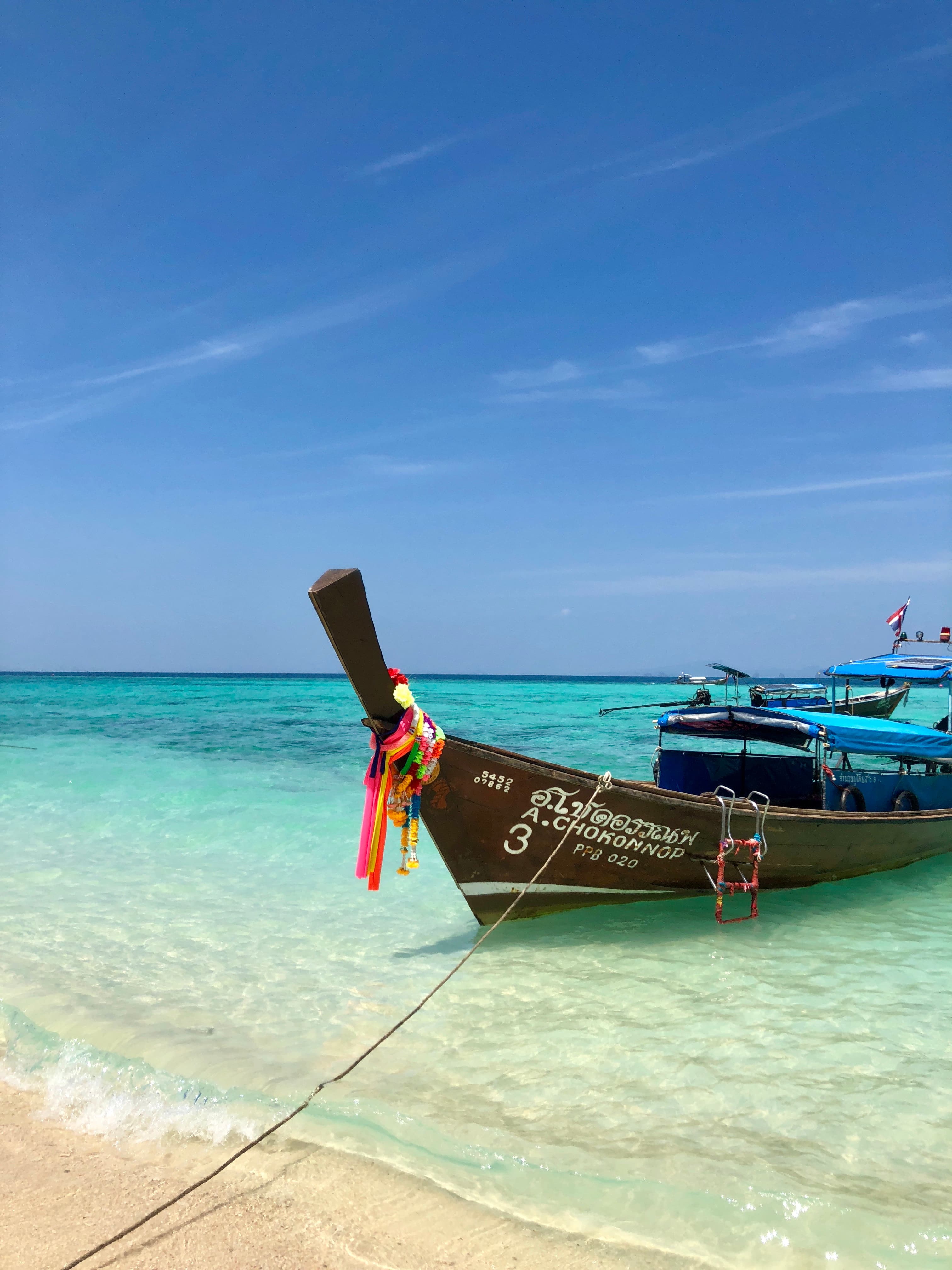 View of a fishing boat resting on shore a beautiful beach under sunny skies