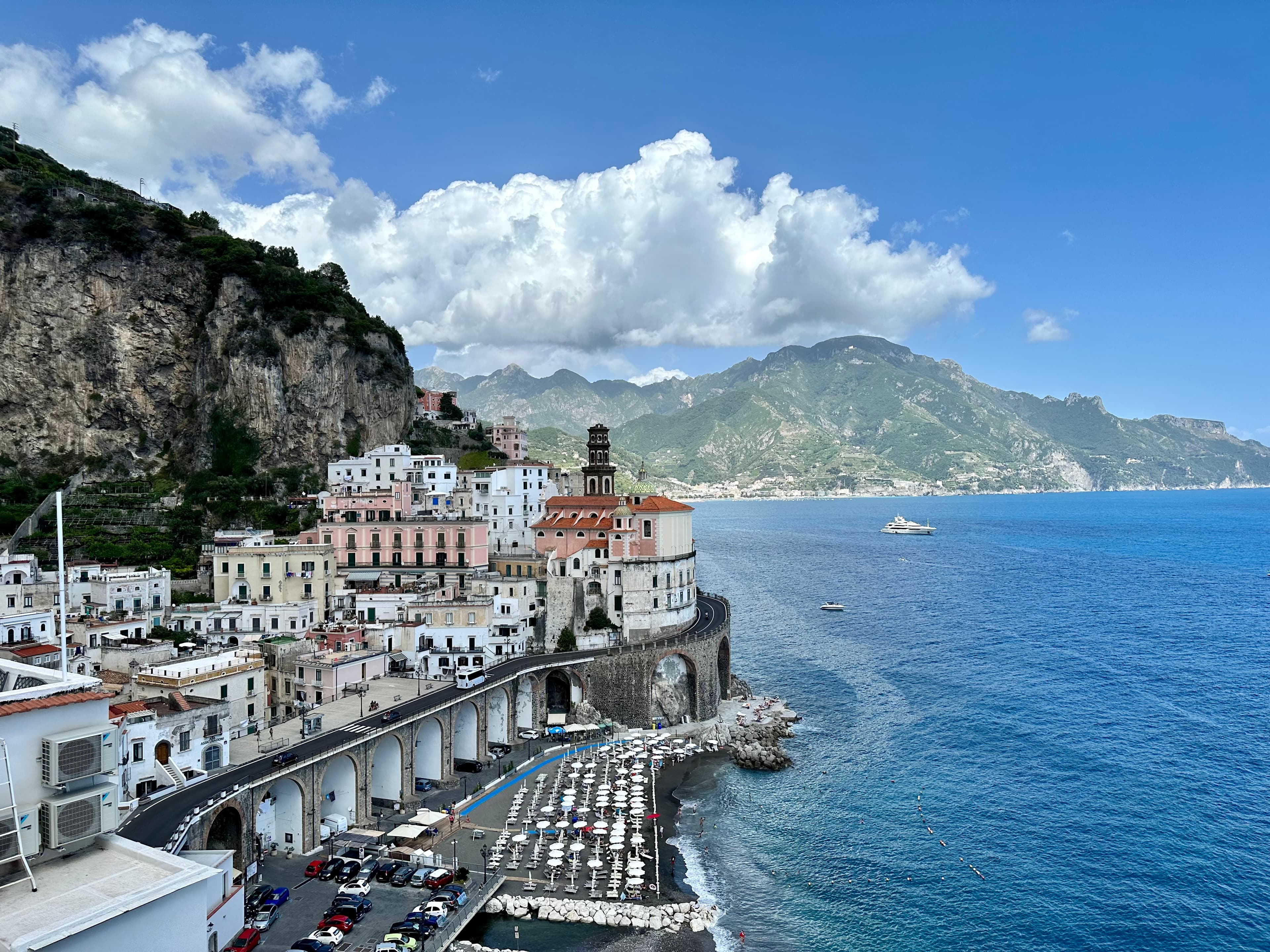 View of a coastal city on a sunny day with mountains in the distance
