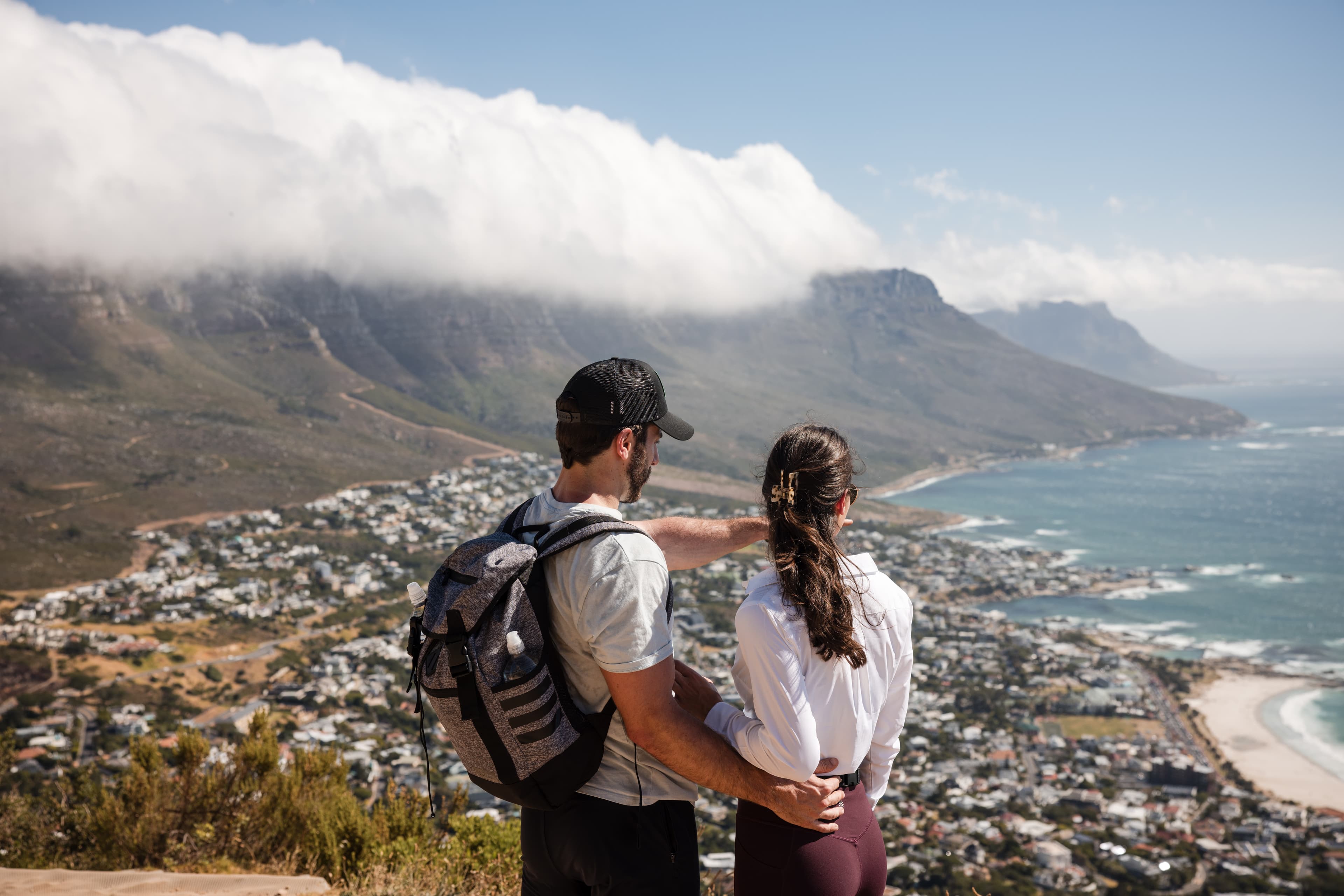 Advisor and partner on a hike overlooking a coastal town on a sunny day