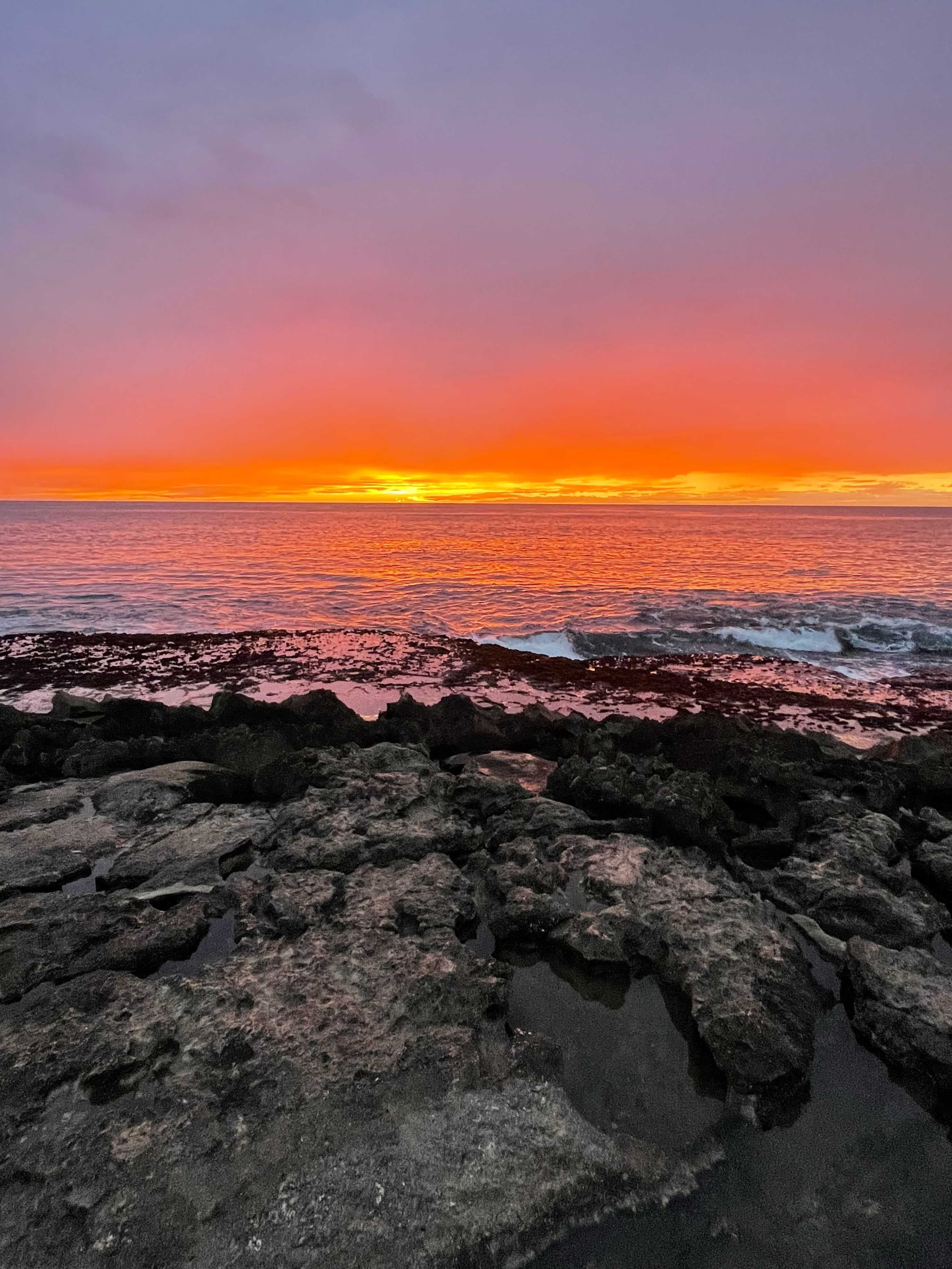 View of a beautiful orange sunset over the sea in Oahu
