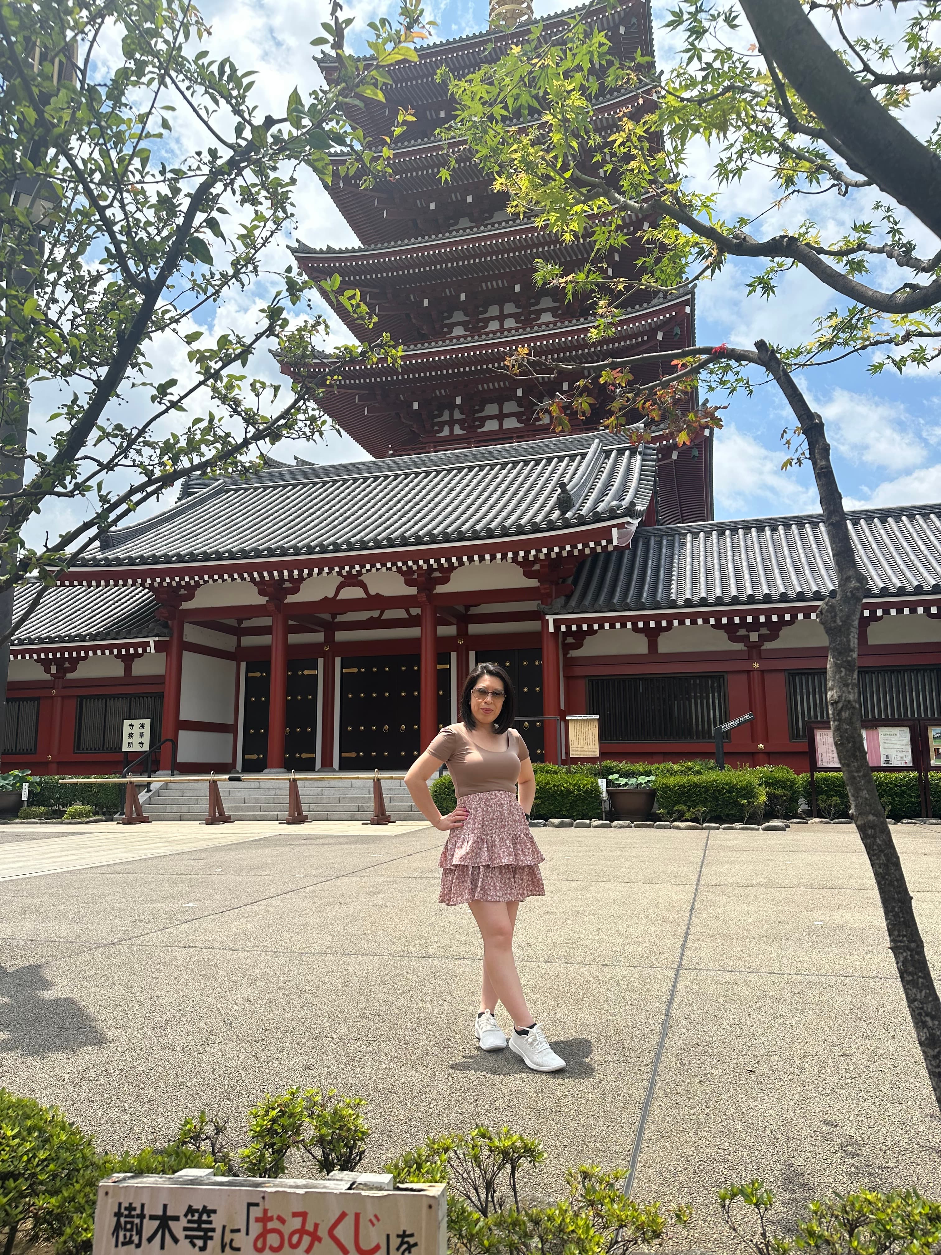 Advisor posing with hands on hips outdoors in front of a Japanese temple