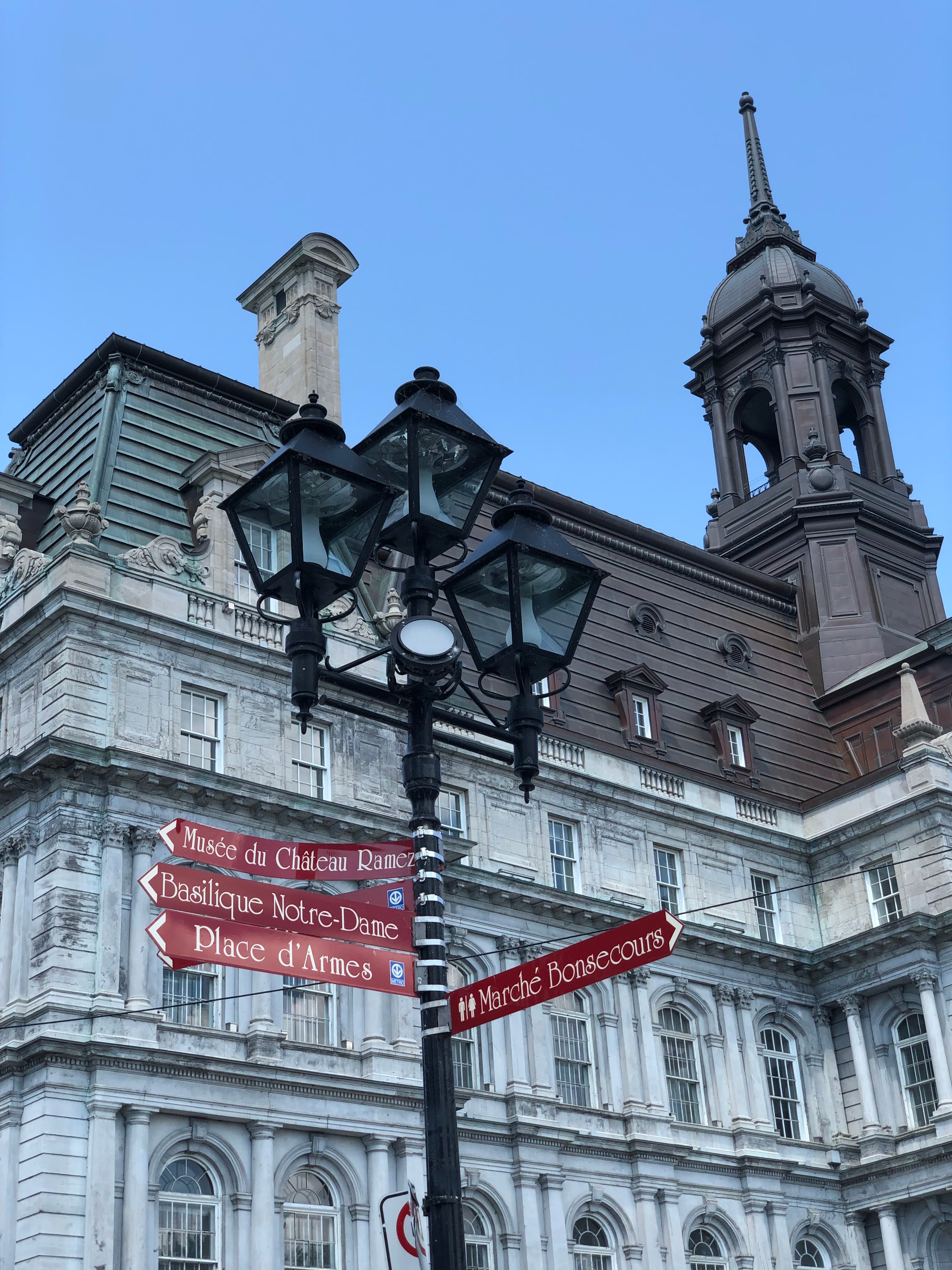 A streetlamp with an old European stone building behind it.