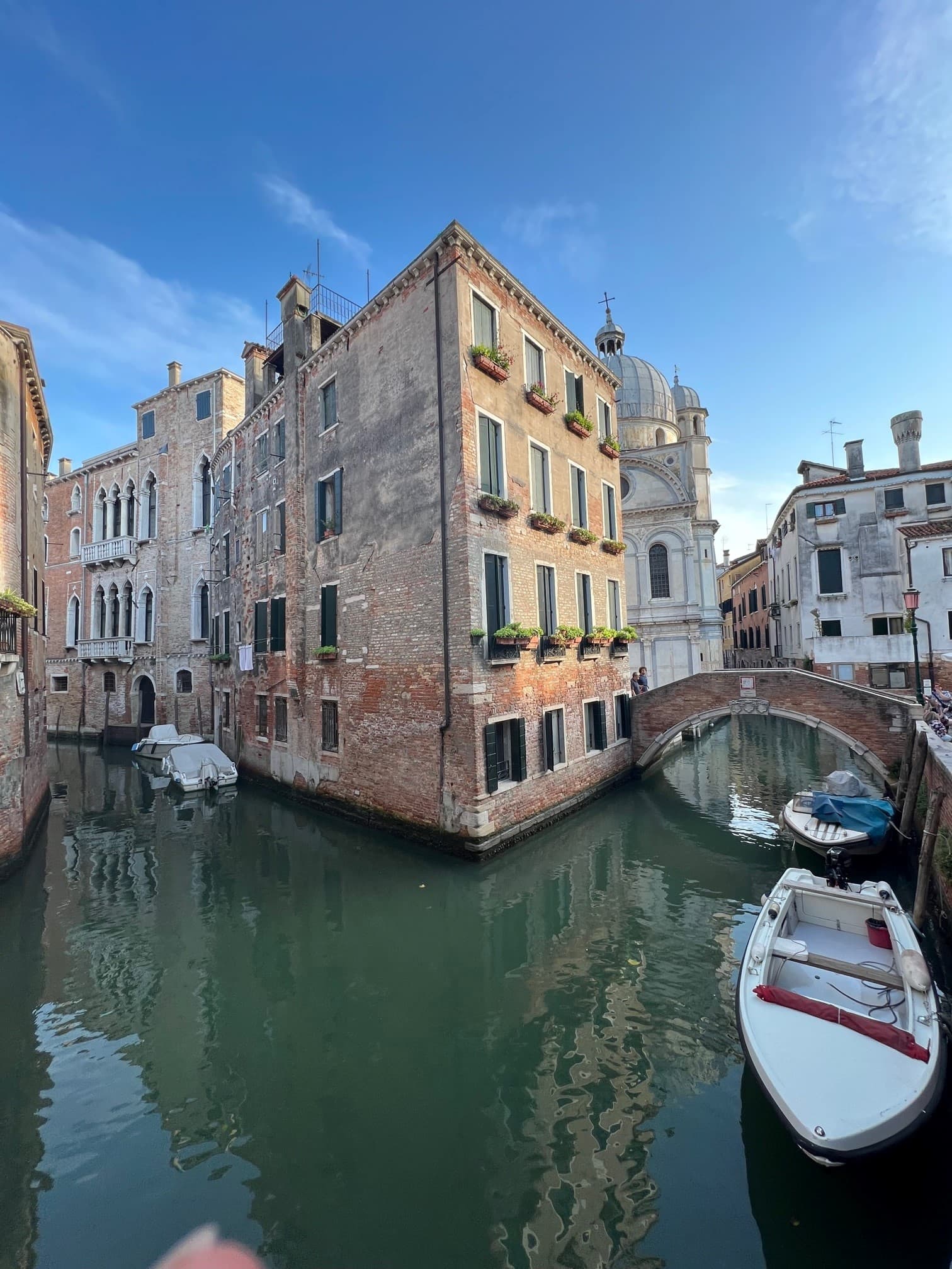 A view of a canal and buildings in the distance on a sunny day. 