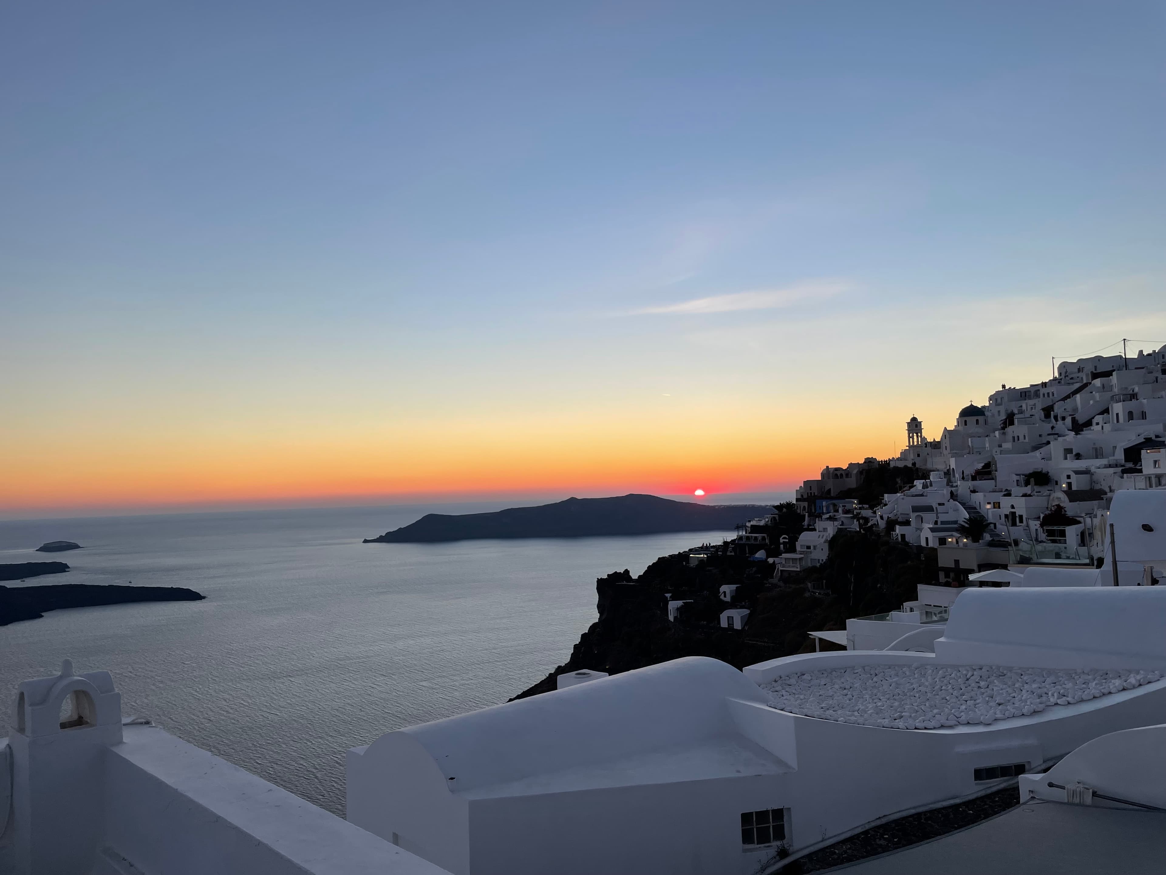 A view of the ocean with a white seaside town. 