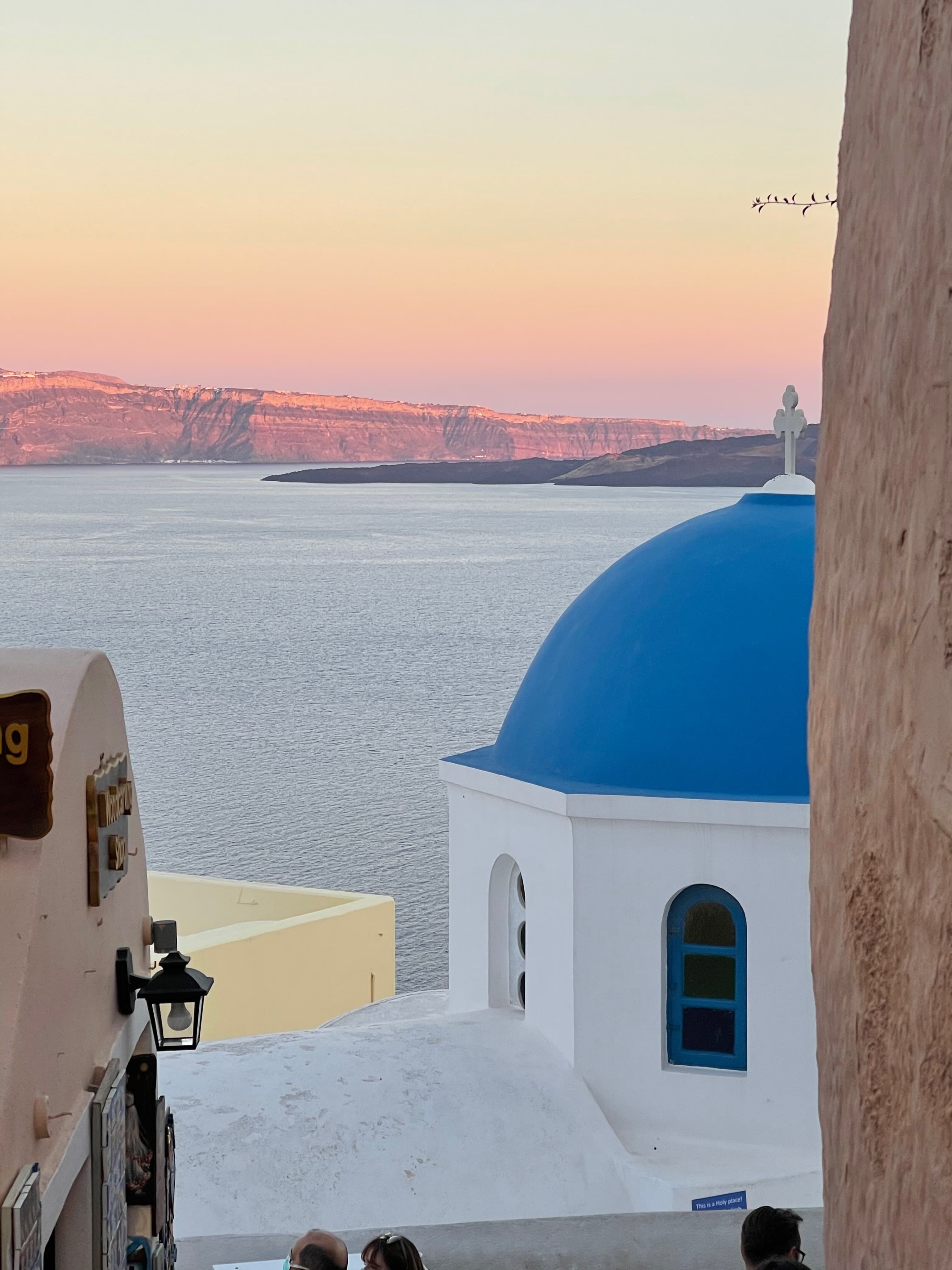 A view of the ocean with white buildings at dusk. 
