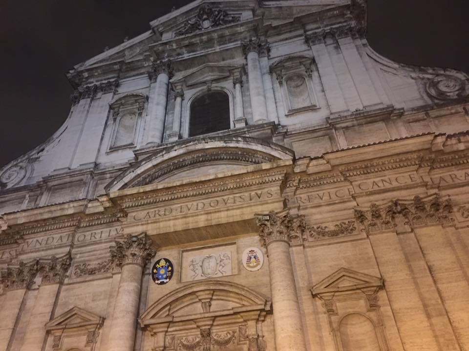 View of the facade of an old building with engravings at night