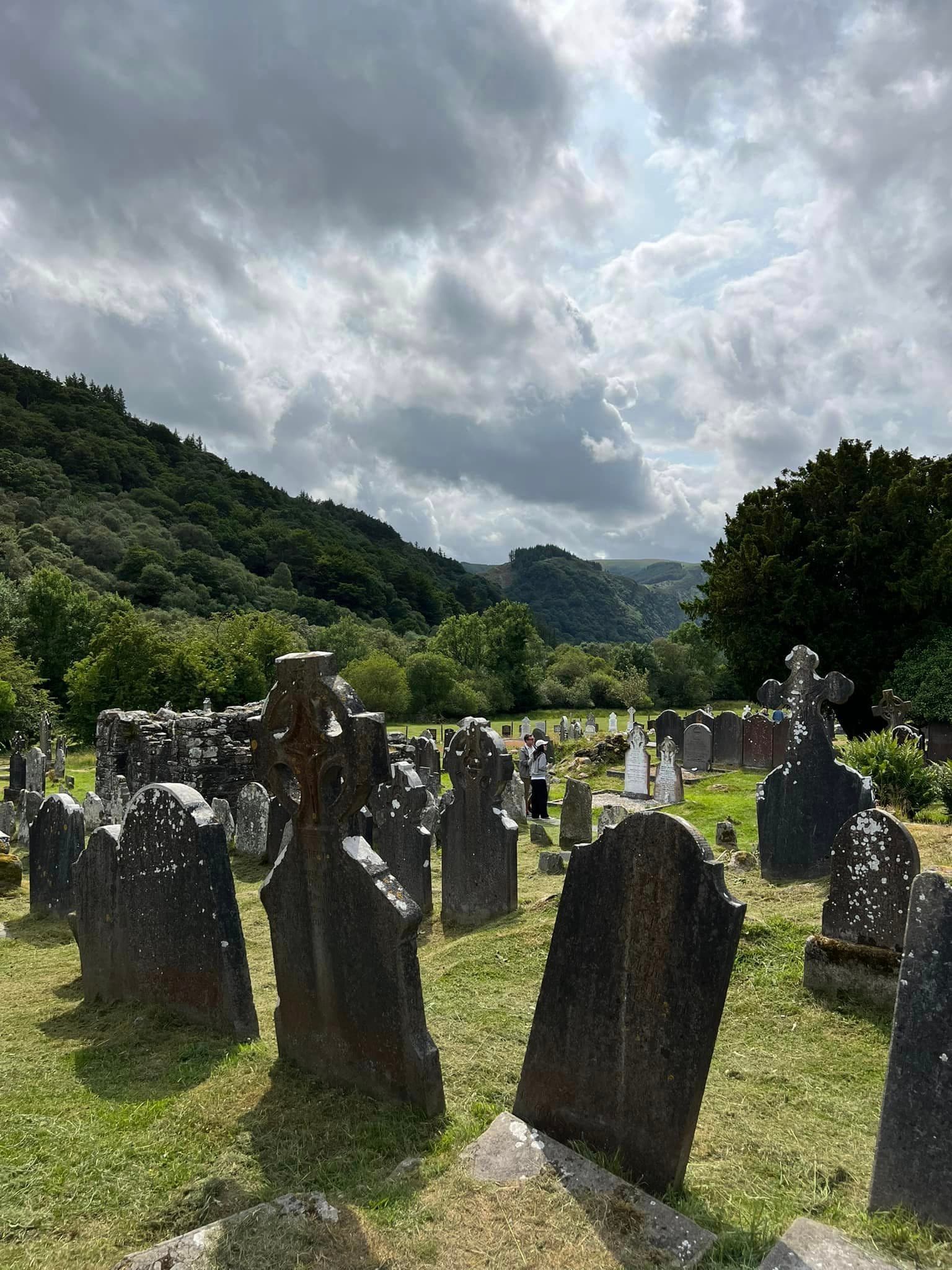 View of an old cemetery with crooked tombstones on a cloudy afternoon
