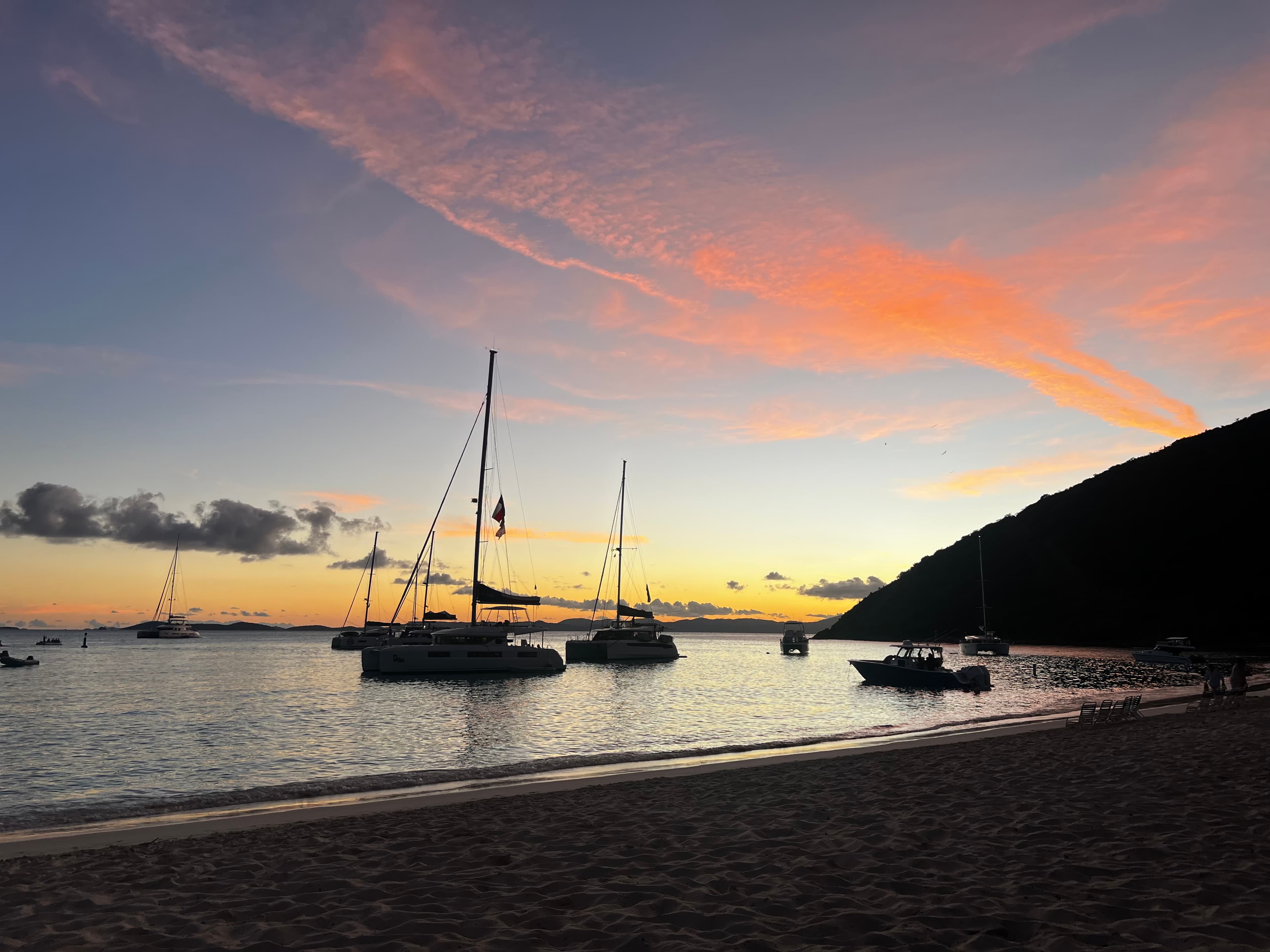 A serene sandy beach with gentle waves lapping at the shore during sunset.