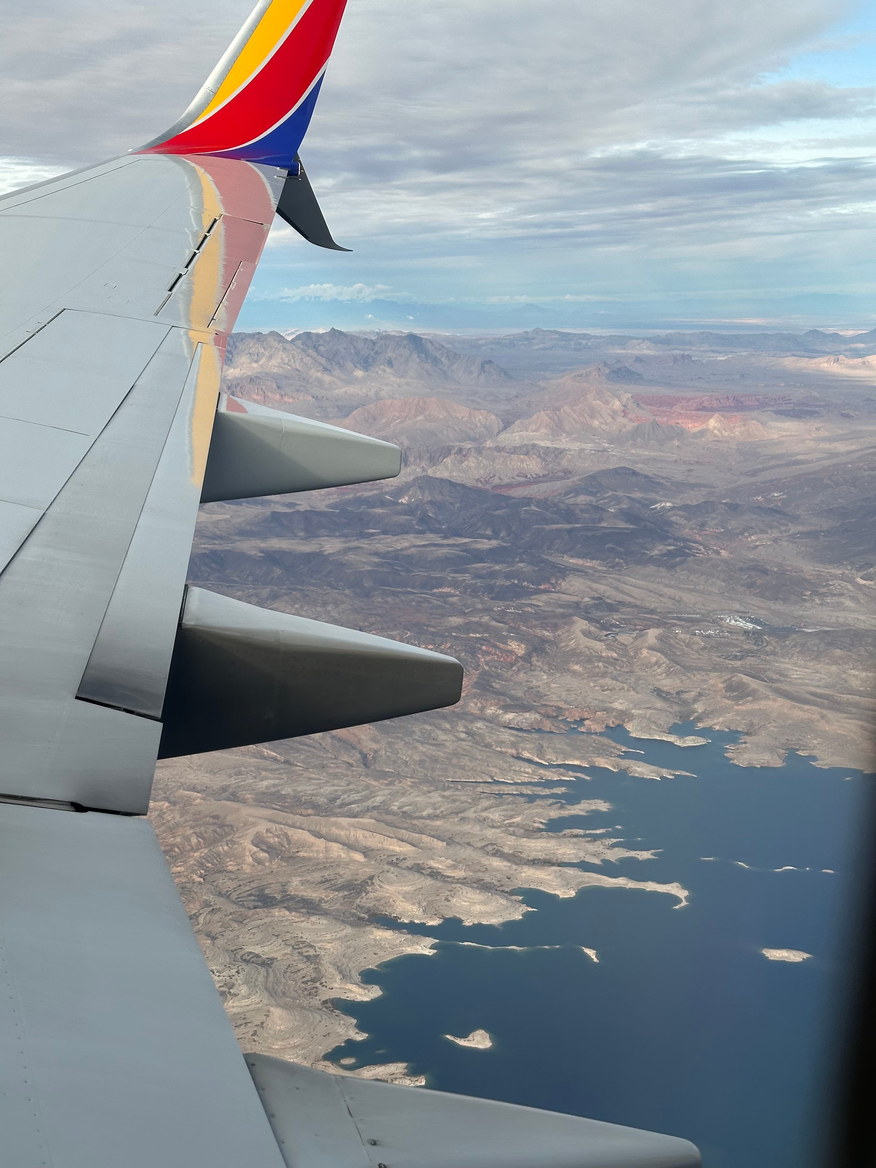 View of a coastal mountain area seen from the window of a plane