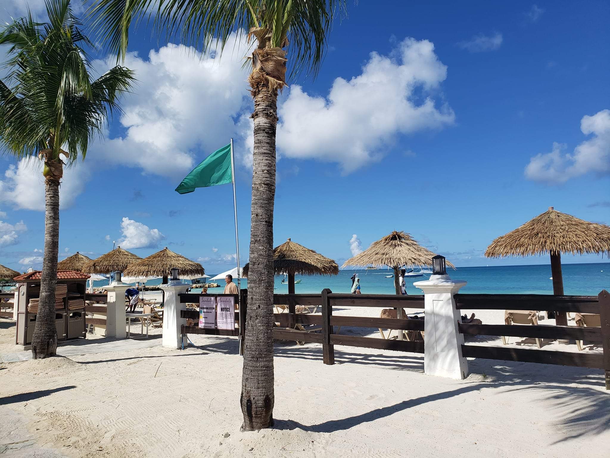 View of thatched umbrellas in a row on a white sandy beach