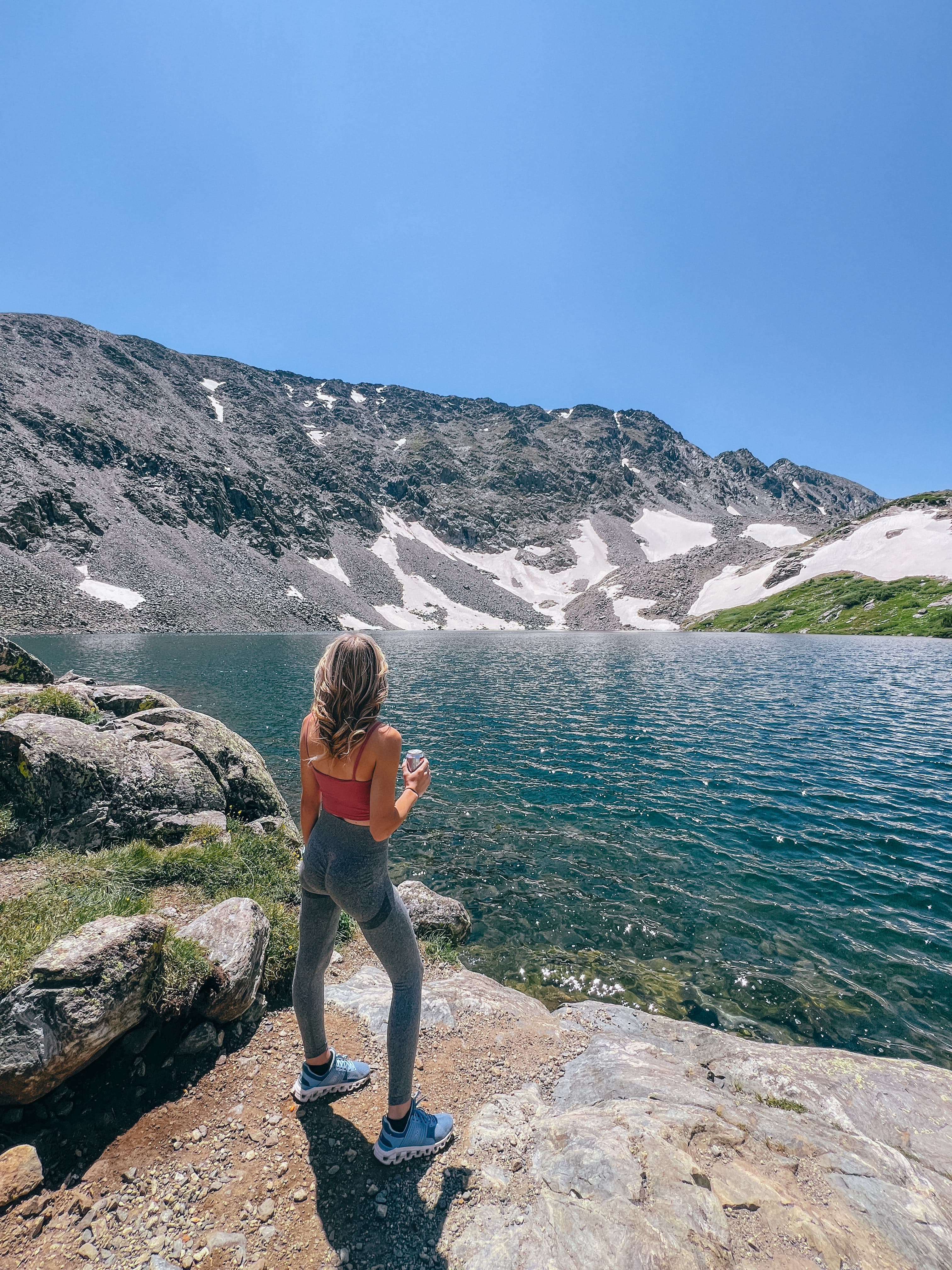 Advisor standing in front of a lake surrounded by mountains on a sunny day