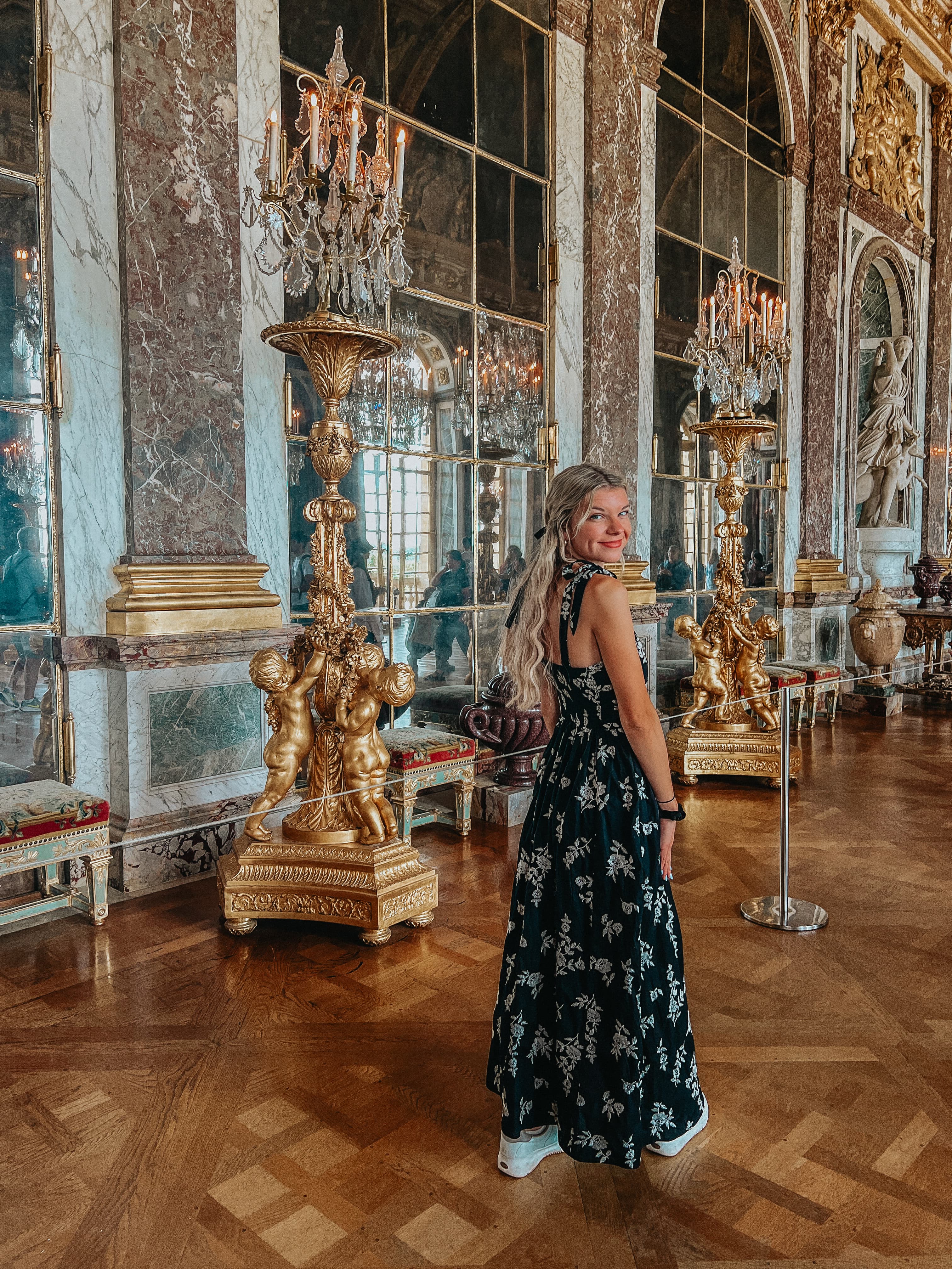 Advisor walking through the Hall of Mirrors at Versailles