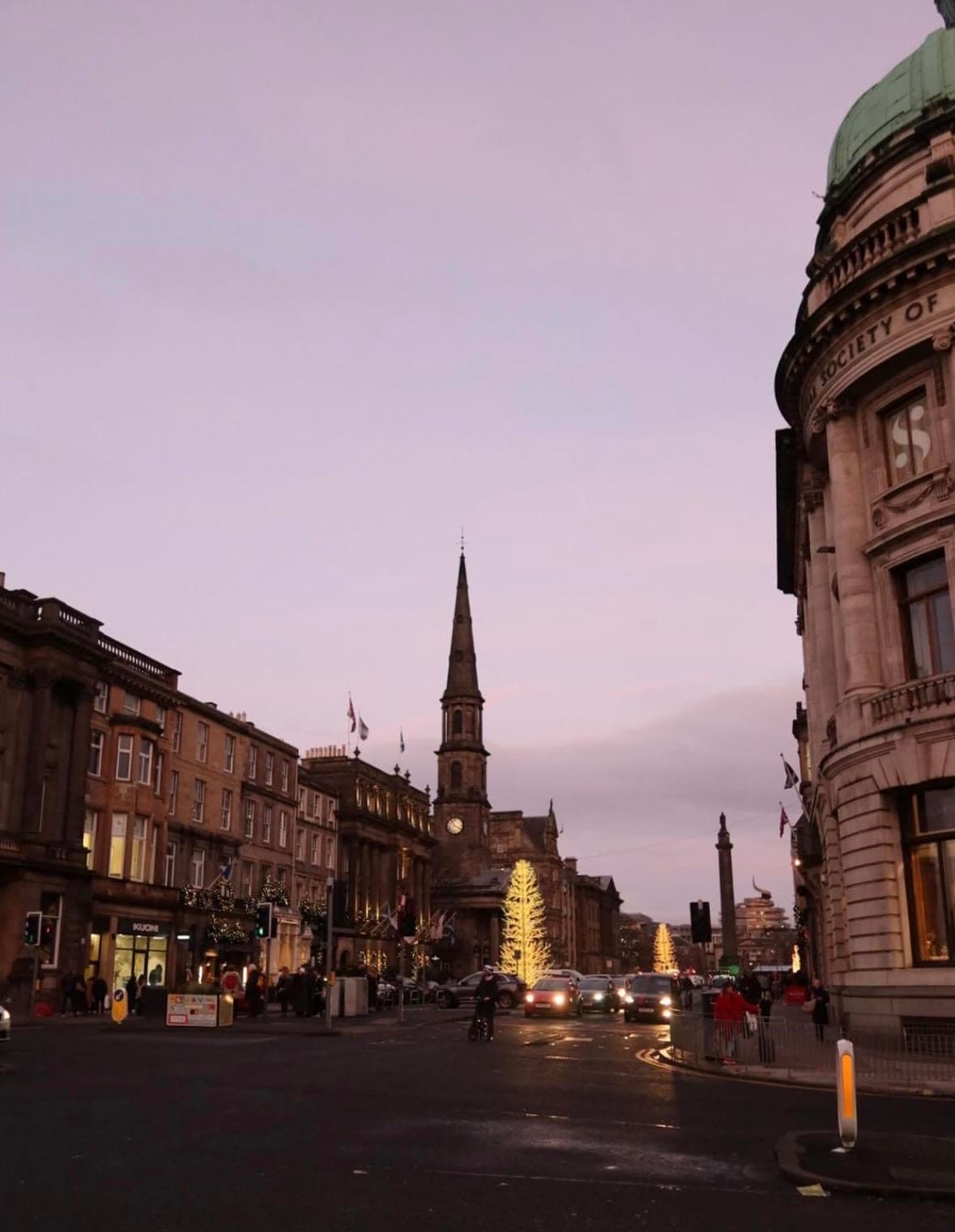 A vibrant city street scene showcasing a clock tower amidst a backdrop of diverse architectural buildings.