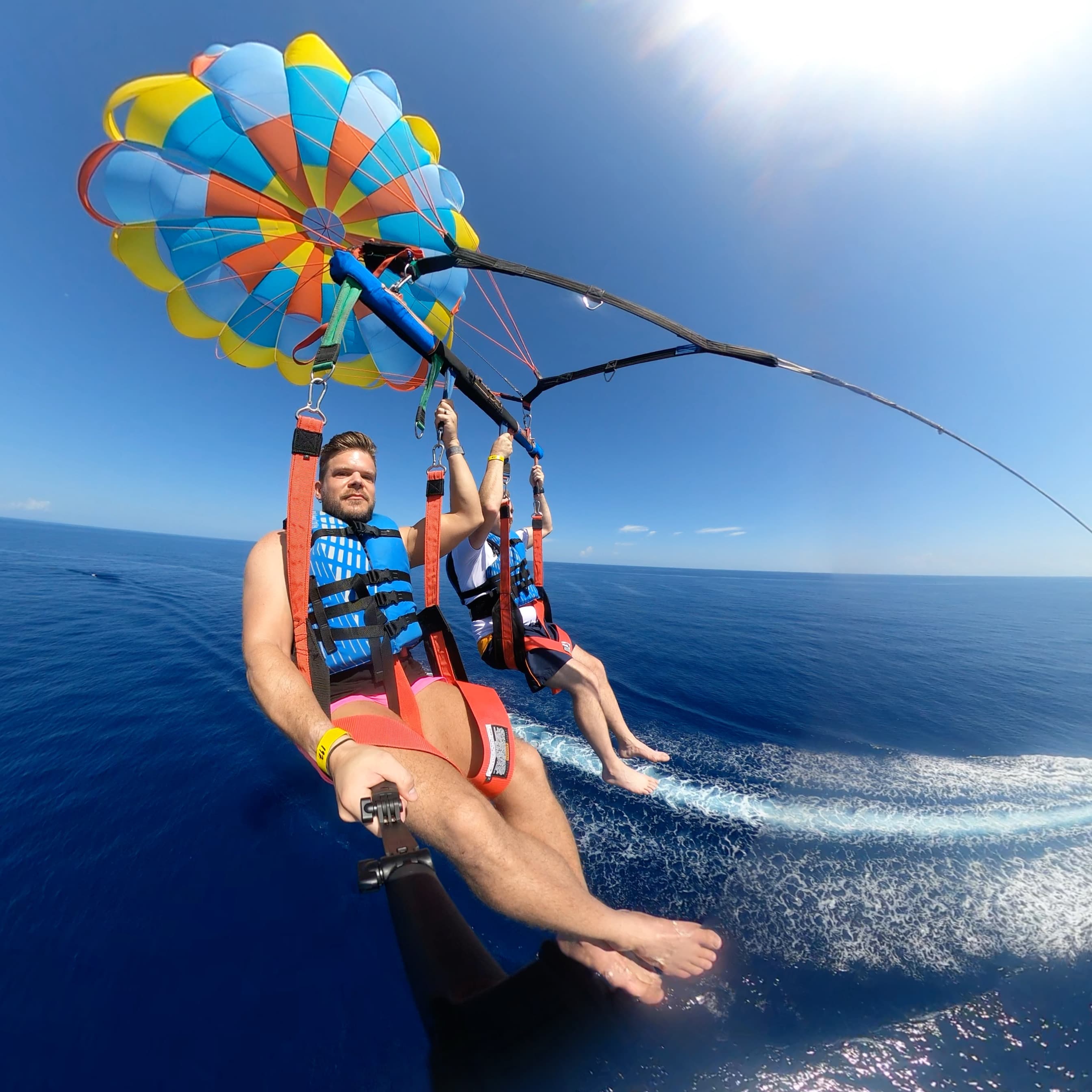 Advisor and a friend parasailing over the sea on a sunny day