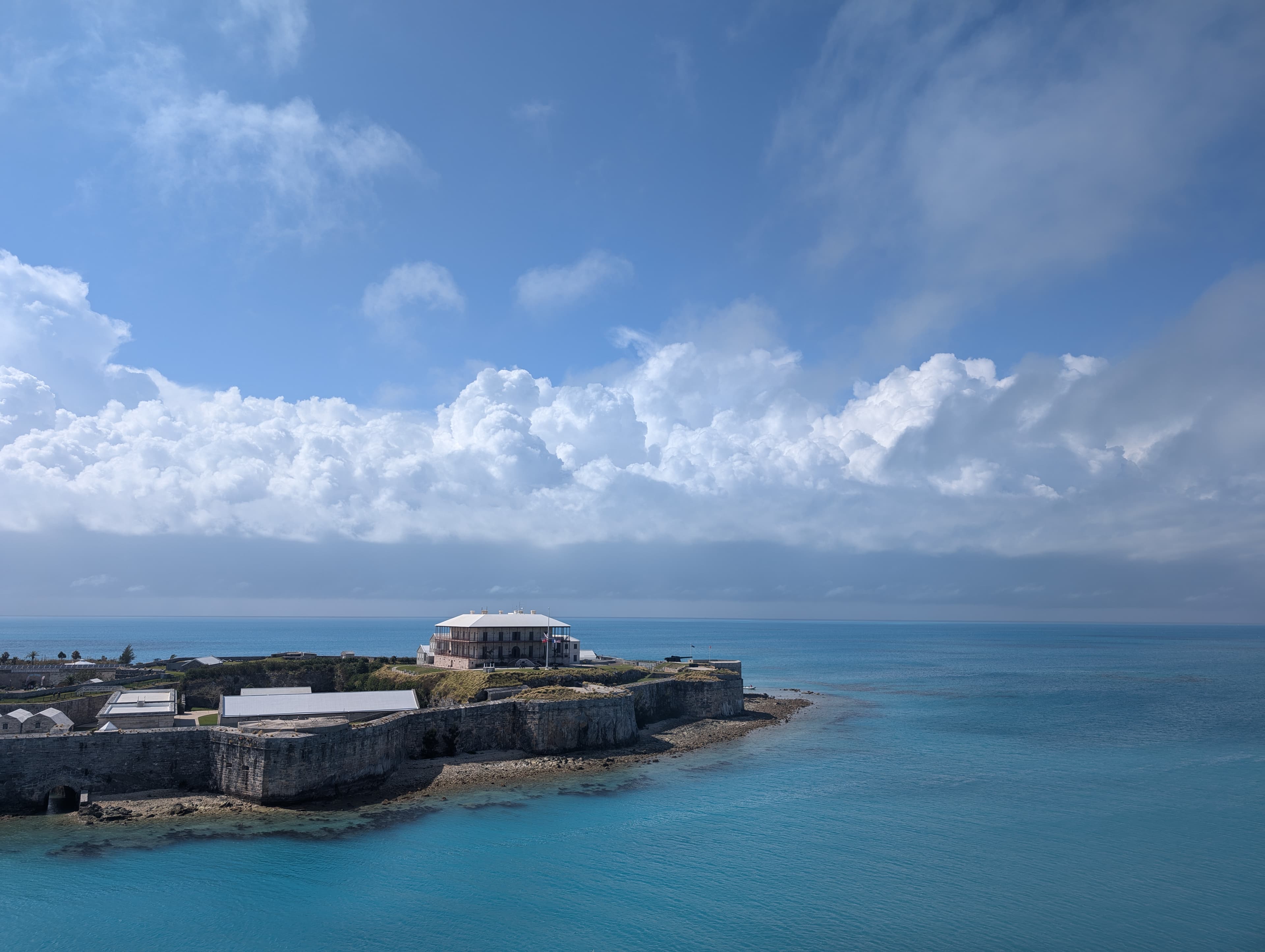 View of a building on a picturesque peninsula jutting out into sea on a sunny day