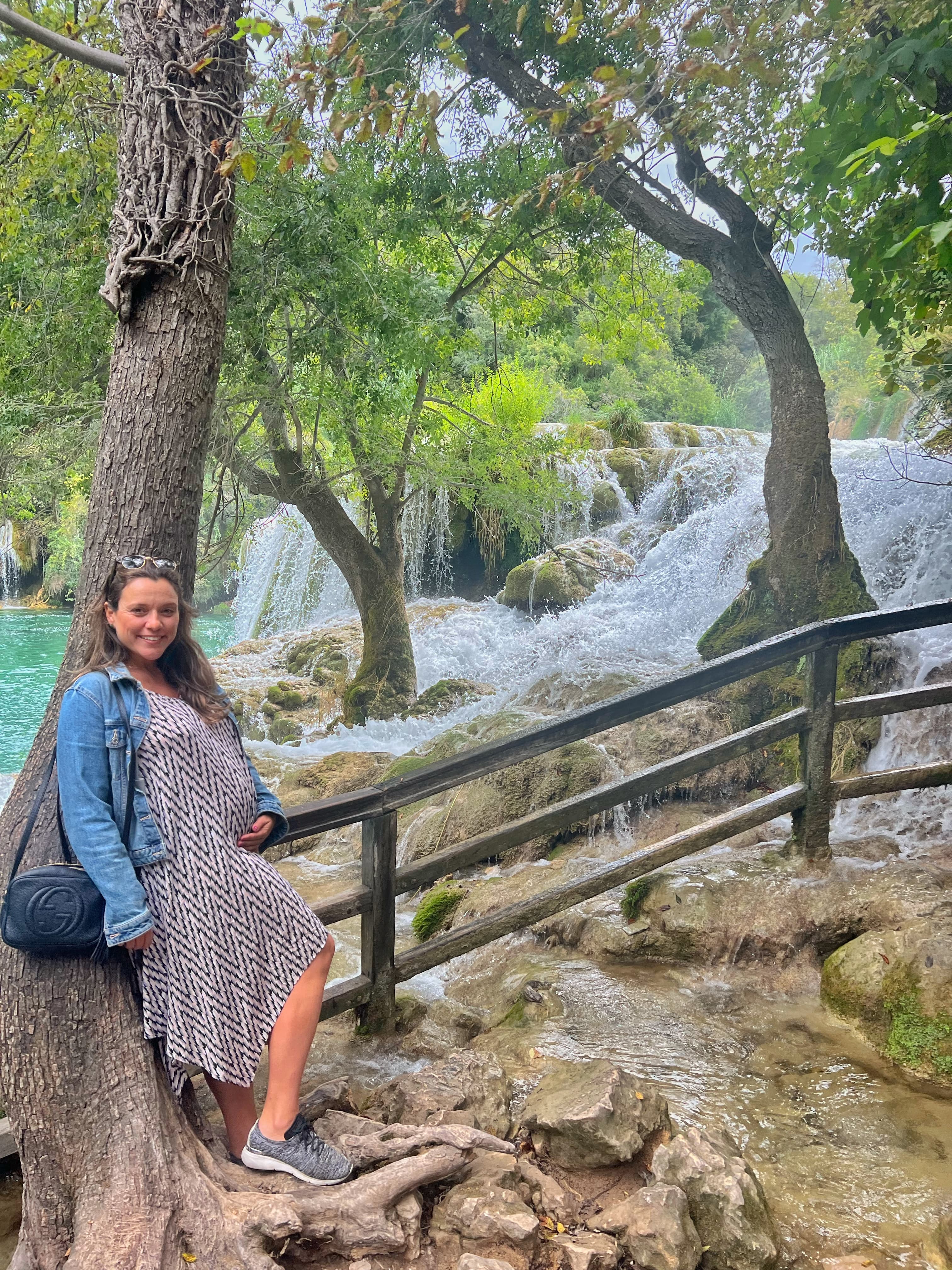 Advisor leaning against a railing beside a beautiful set of waterfalls