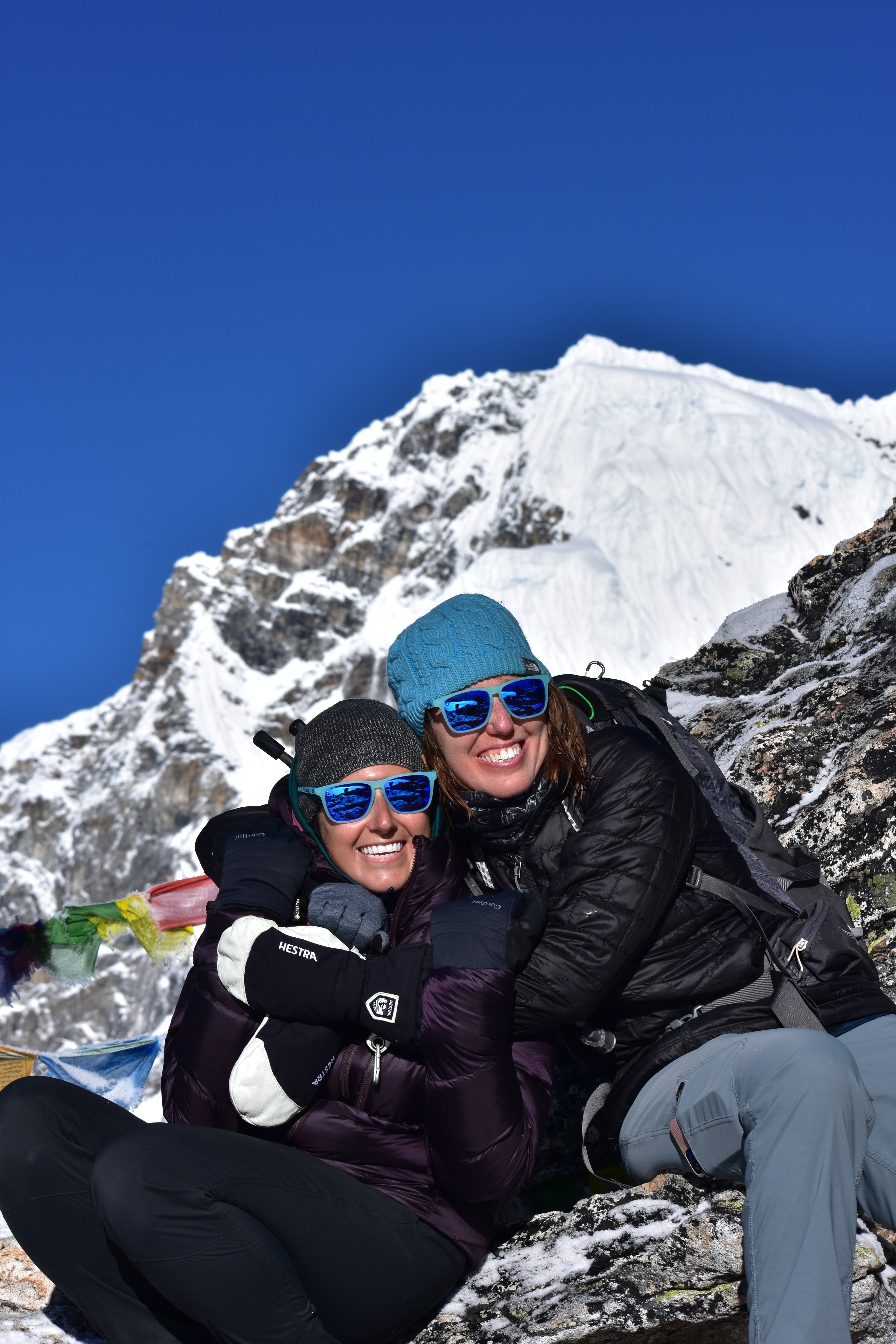 Advisor and a friend sitting side by side and smiling at Everest base camp